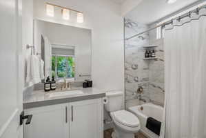 Guest room en-suire bathroom featuring a white vanity with a gray countertop, an undermount sink, and a gold-tone faucet.