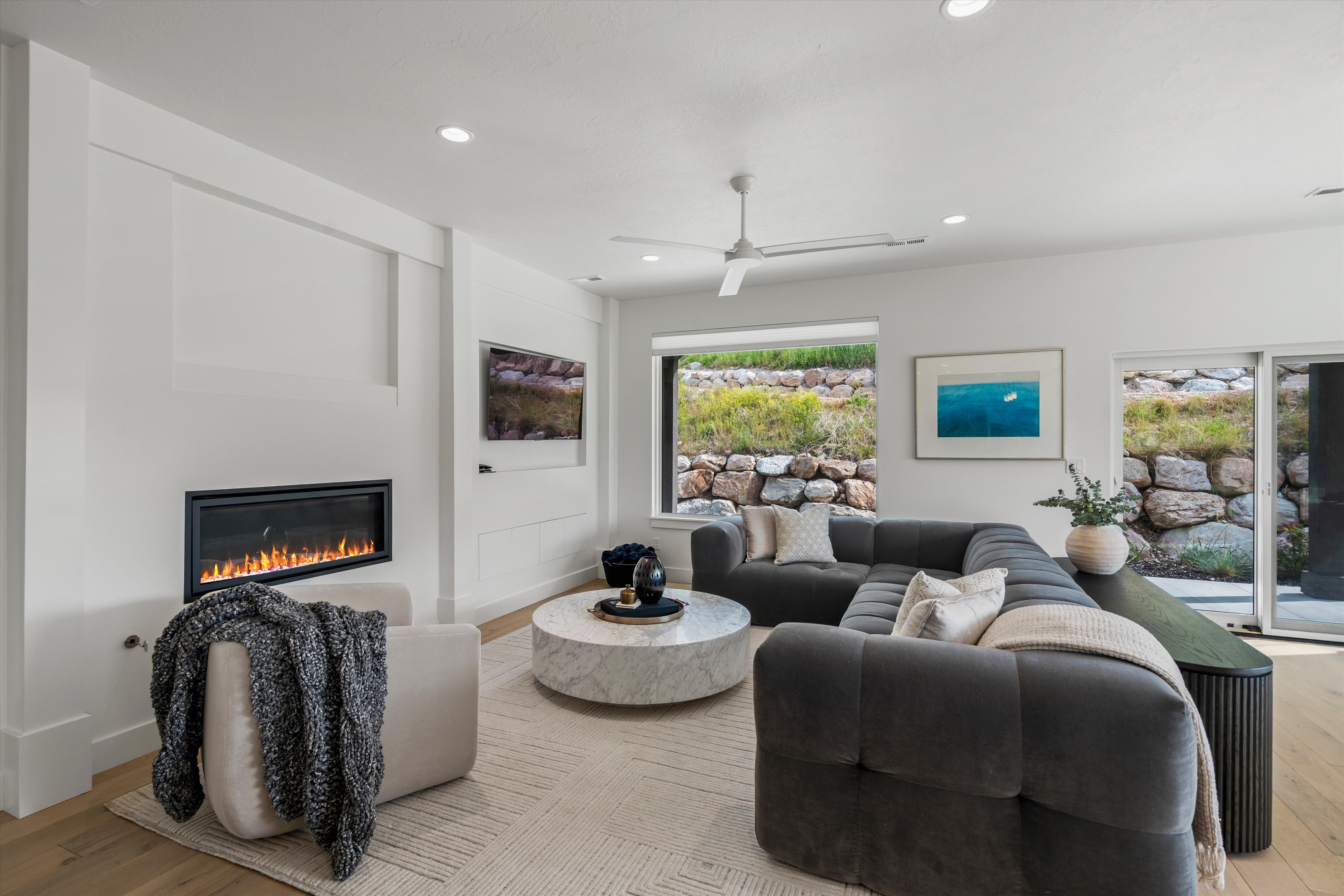 Bright interior featuring fireplace and large picture window.