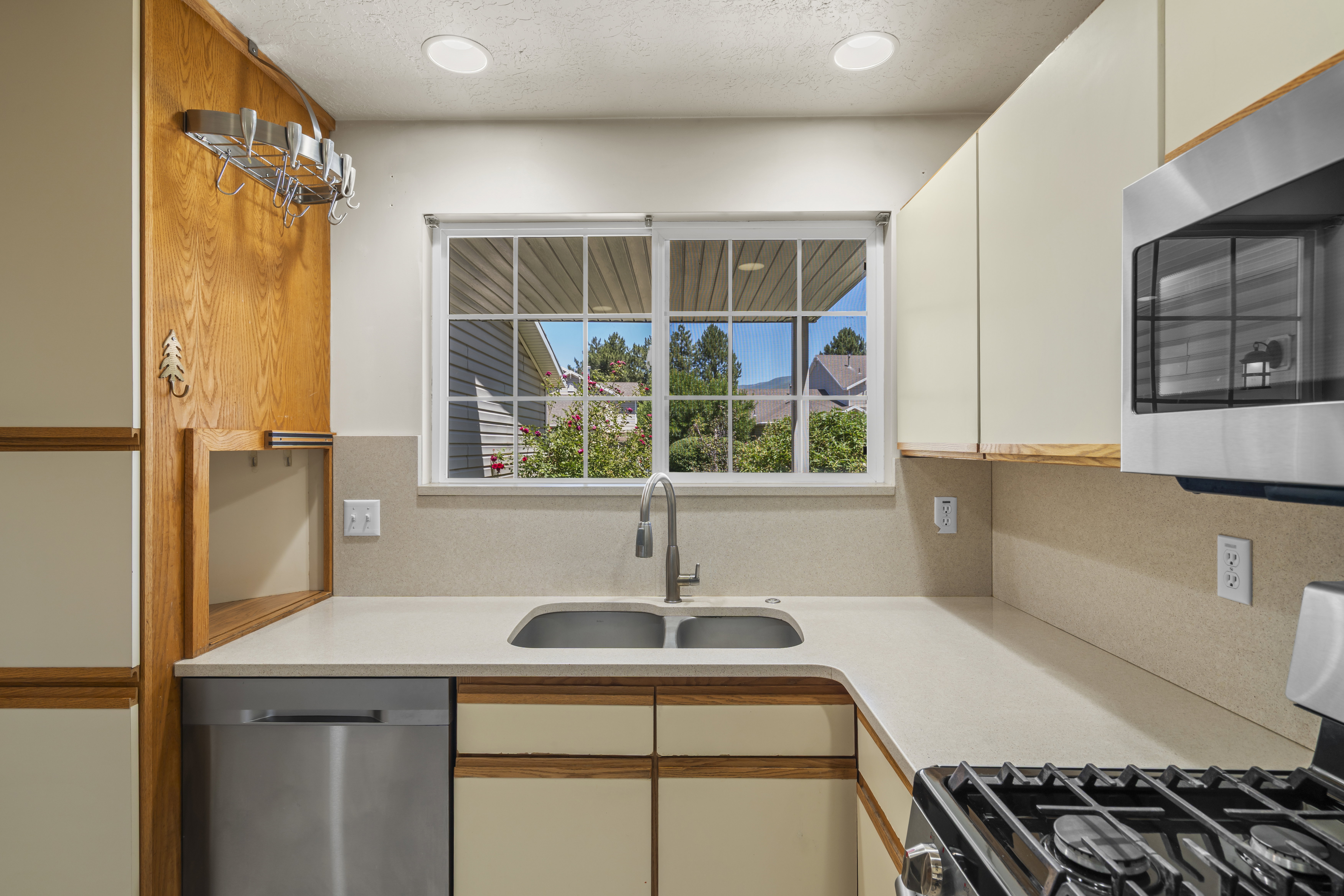 Kitchen featuring a double basin sink, stainless steel dishwasher, and built-in microwave