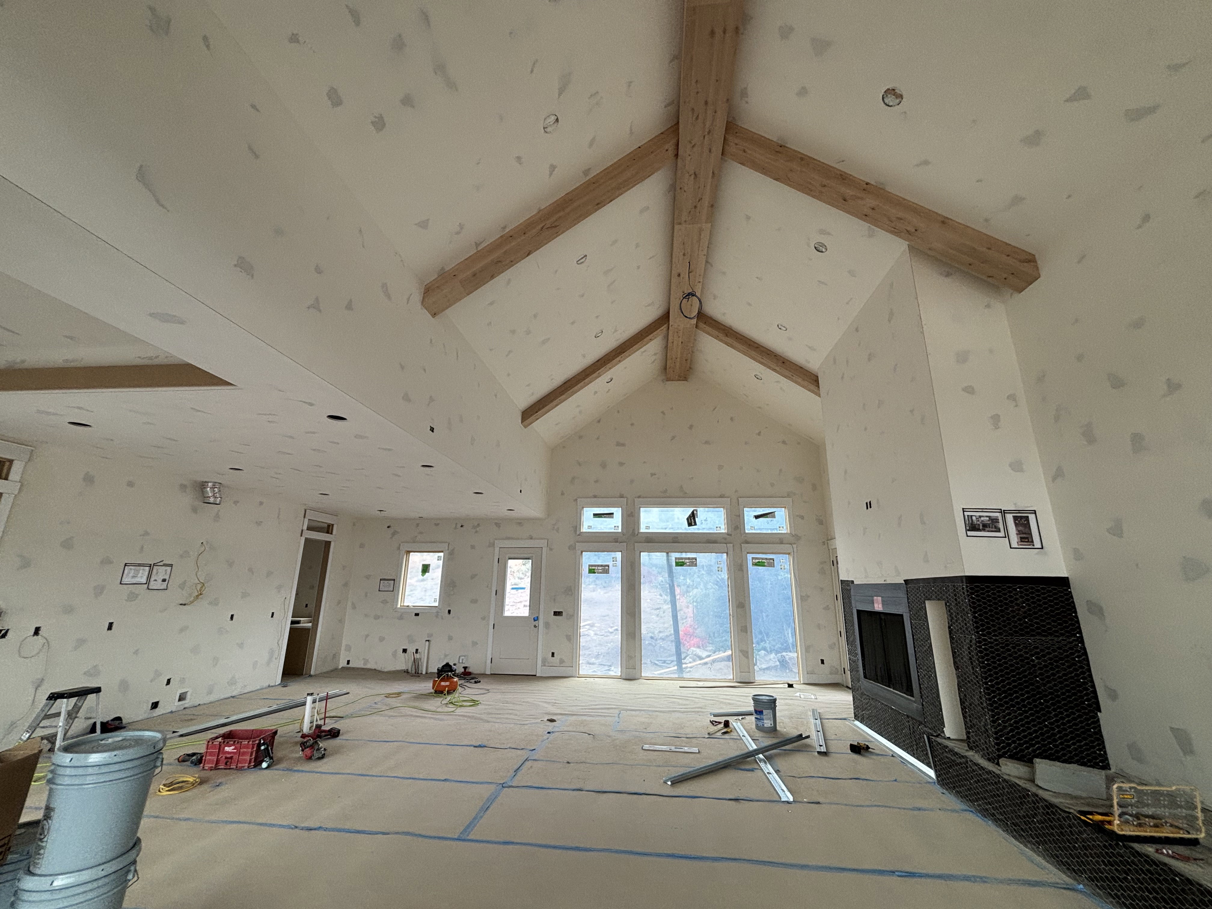 Living room featuring a Vaulted ceiling with exposed wood beams, and a fireplace