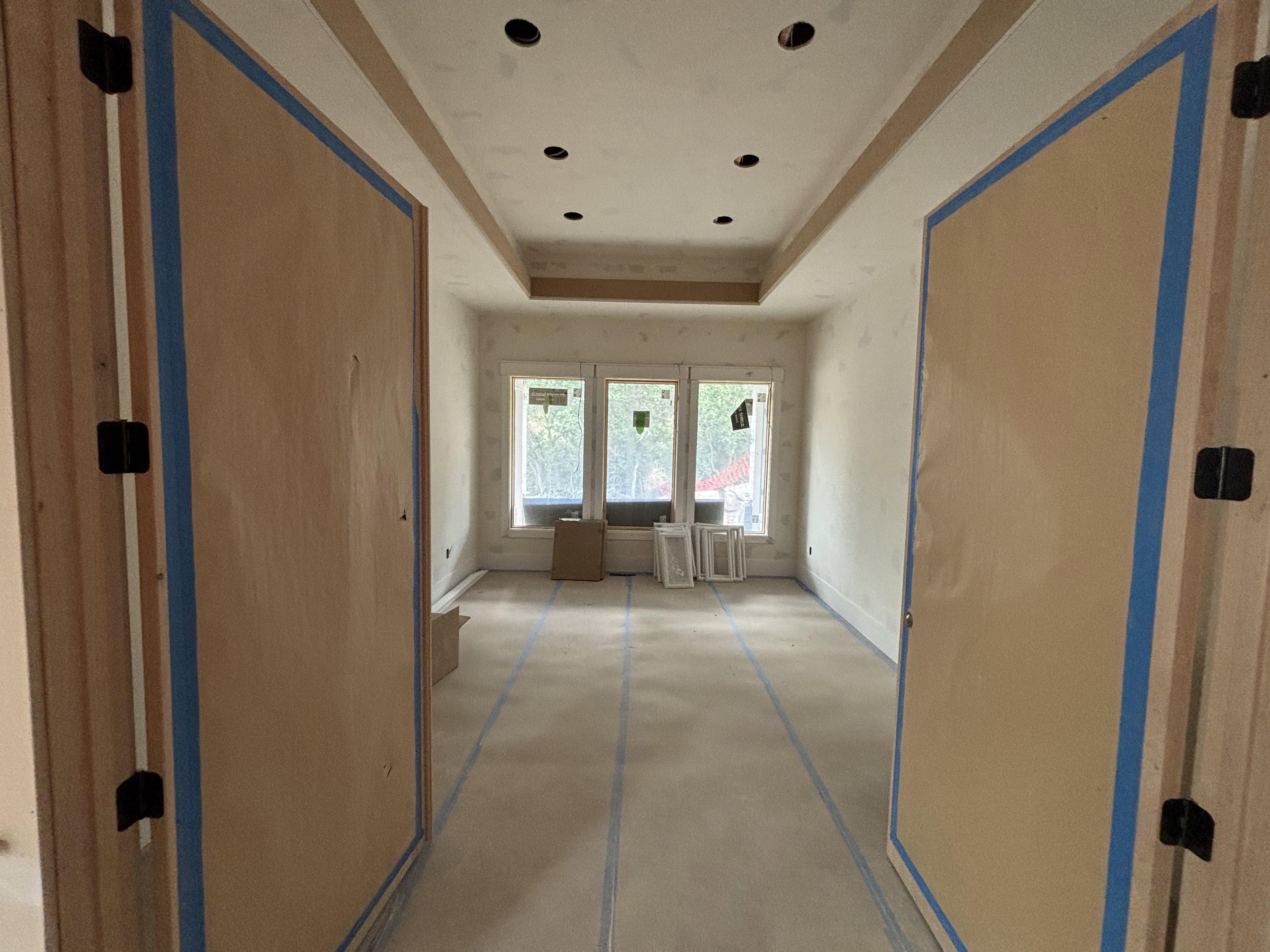 Office/library featuring a tray ceiling with recessed lighting, three large windows, and an expansive doorway