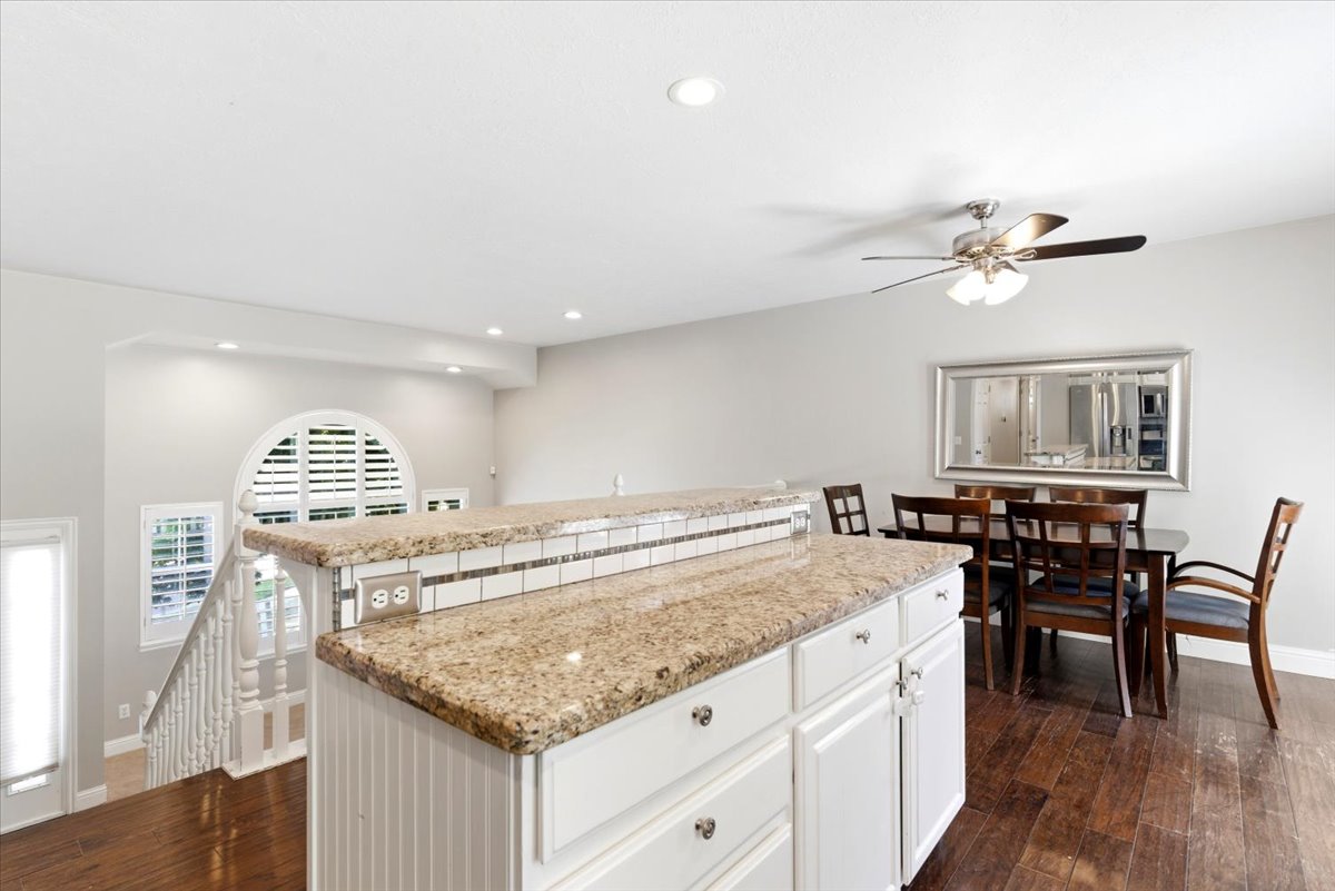 Kitchen island featuring granite countertops and white beadboard paneling