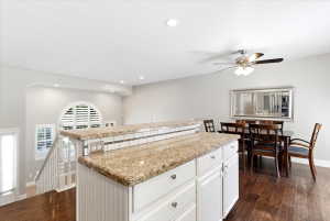 Kitchen island featuring granite countertops and white beadboard paneling