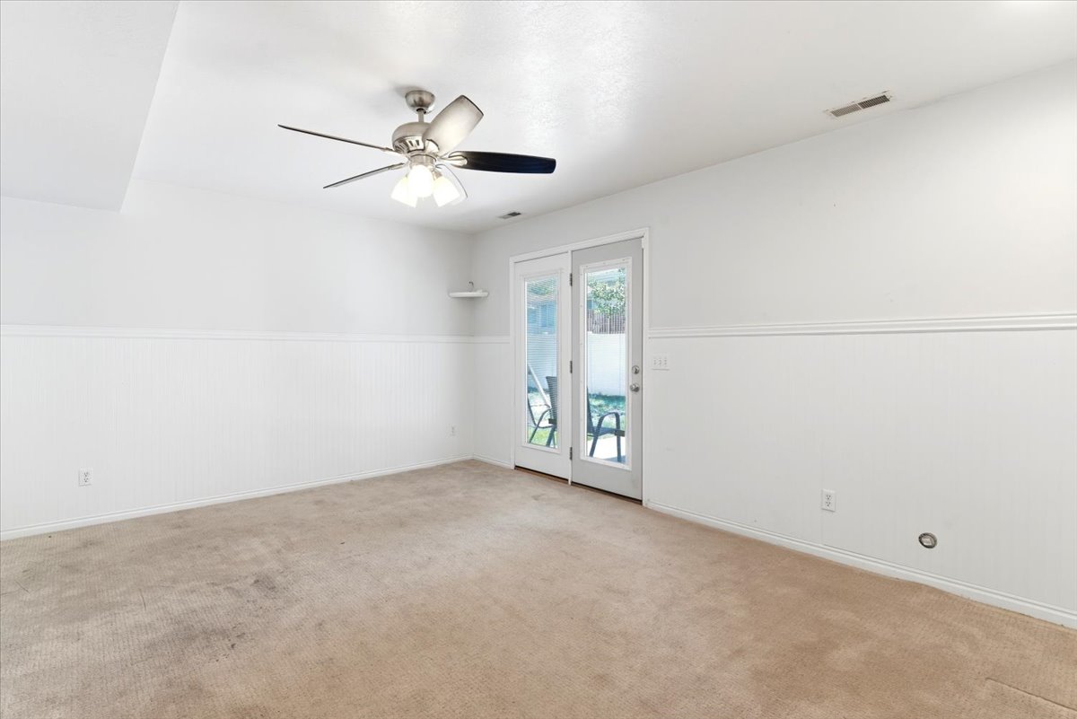 Neutral wall finishes with wainscoting and a ceiling fan with integrated lighting