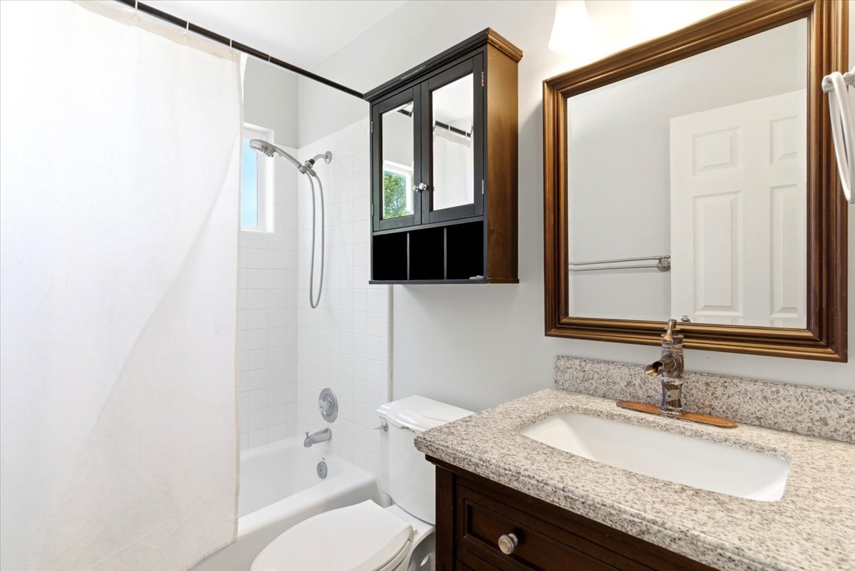 Bathroom featuring a white subway tile shower surround, a built-in tub, and a window for natural light