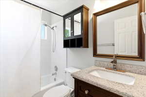 Bathroom featuring a white subway tile shower surround, a built-in tub, and a window for natural light