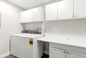 Functional laundry area featuring white cabinetry, a built-in countertop, and dark floor tiles