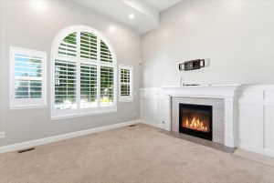 Vaulted ceilings complement an arched window with plantation shutters