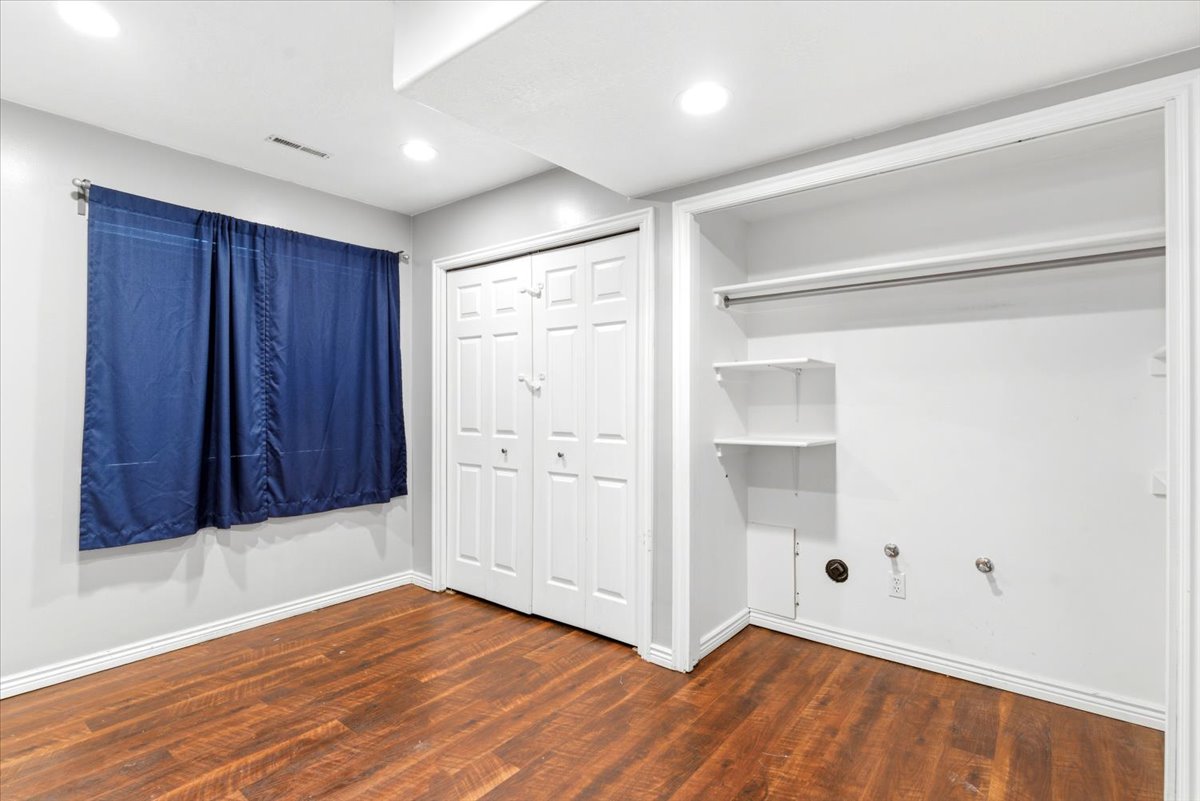 Room featuring wood-finish flooring, recessed lighting, and a window with a curtain rod