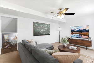 Living area featuring recessed ceiling beams, a ceiling fan with integrated lighting, and a wood-finish media console