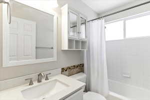 Bathroom featuring a vanity with an integrated sink, a speckled countertop, and a tiled backsplash