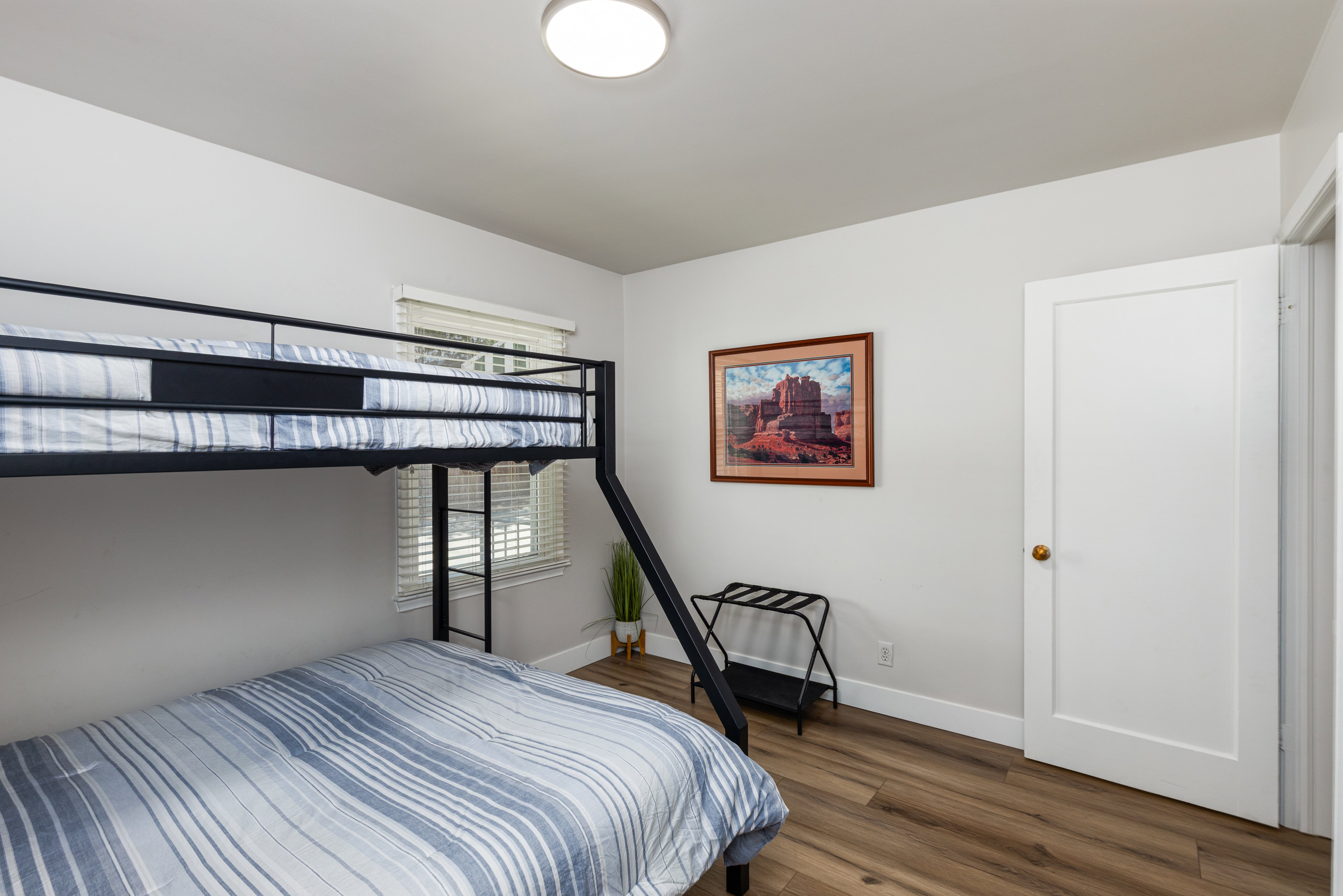 Bright room with wood-finish flooring and a window featuring blinds