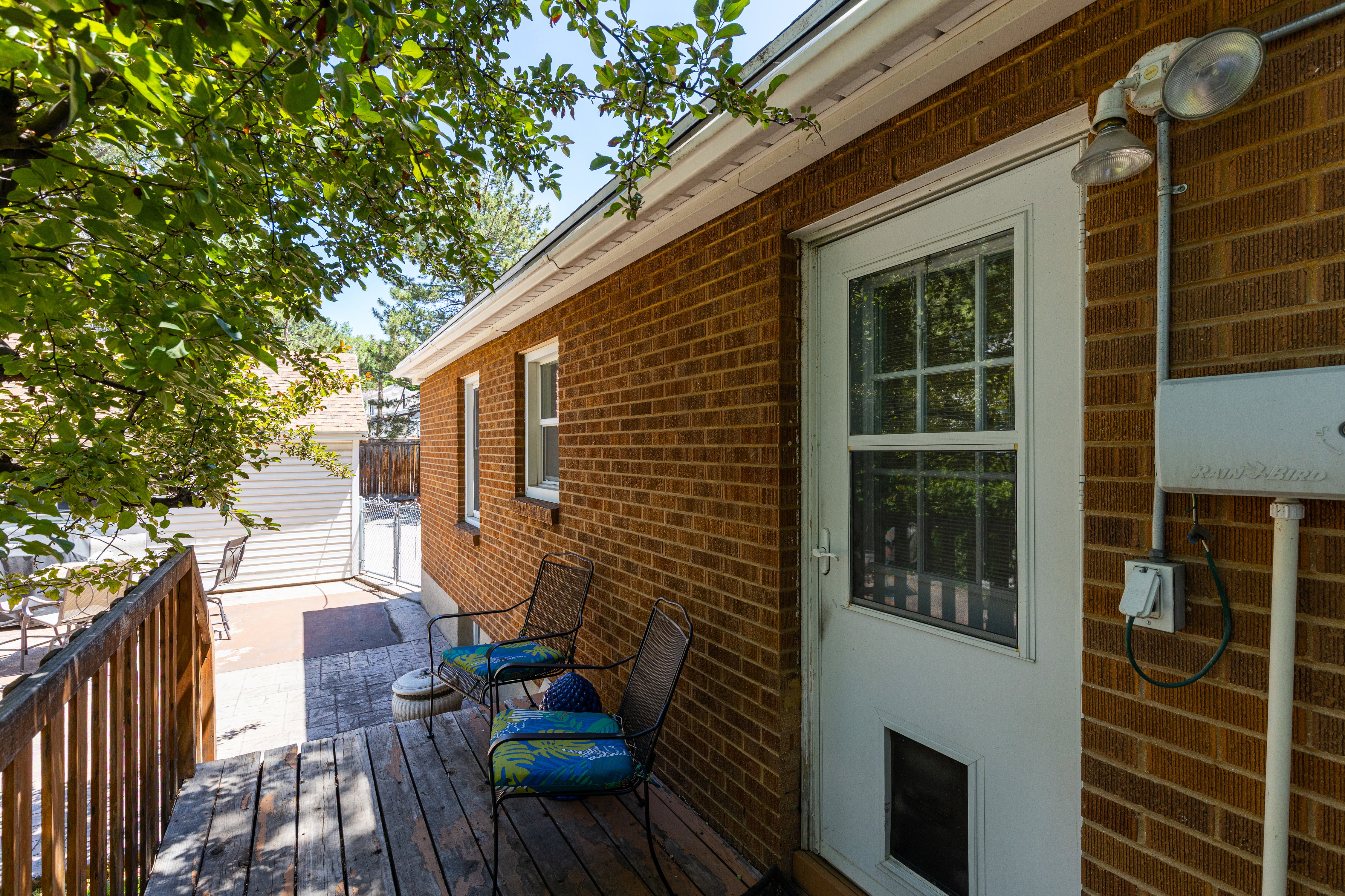 Brick exterior featuring a wood deck and white-framed windows
