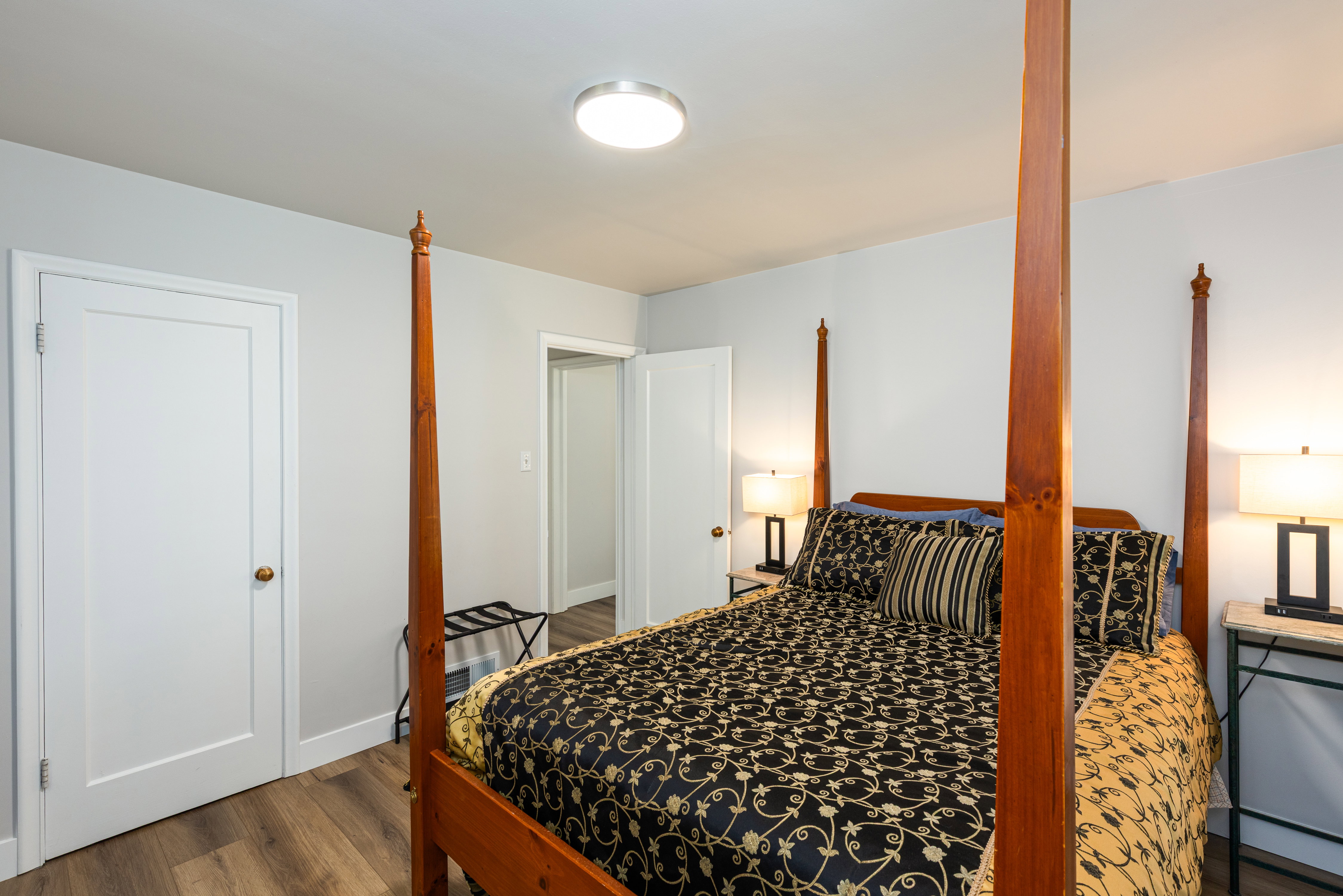 Room featuring light gray wall paint, wood-finish flooring, a white trim package, and a flush-mount ceiling light