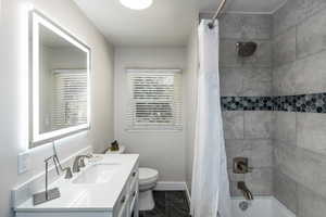 Modern bathroom featuring a back-lit vanity mirror, white countertop, and a built-in tub with a tiled shower surround