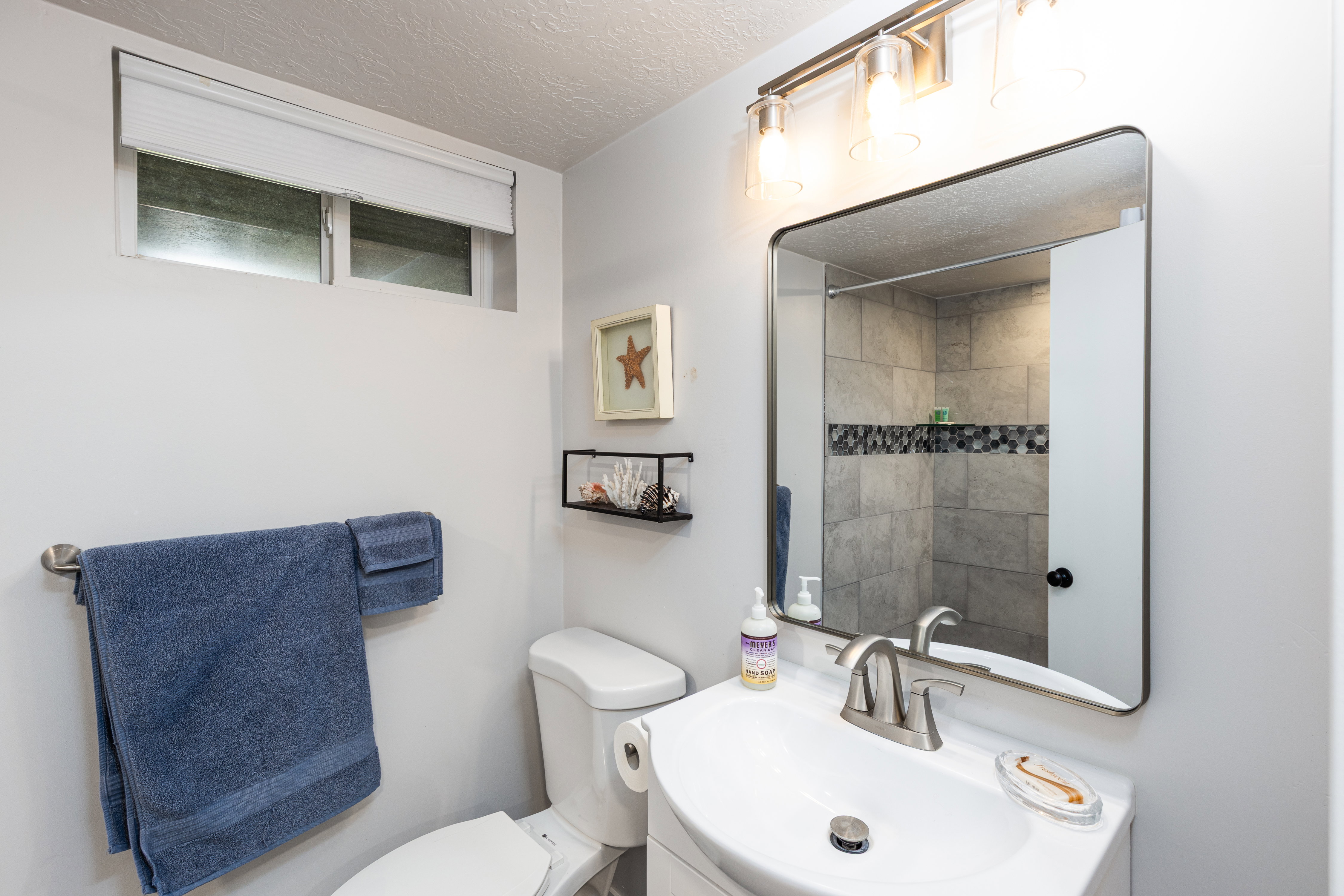 Bathroom featuring a contemporary vanity with an integrated sink, a brushed nickel faucet, and a wall-mounted mirror