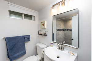 Bathroom featuring a contemporary vanity with an integrated sink, a brushed nickel faucet, and a wall-mounted mirror