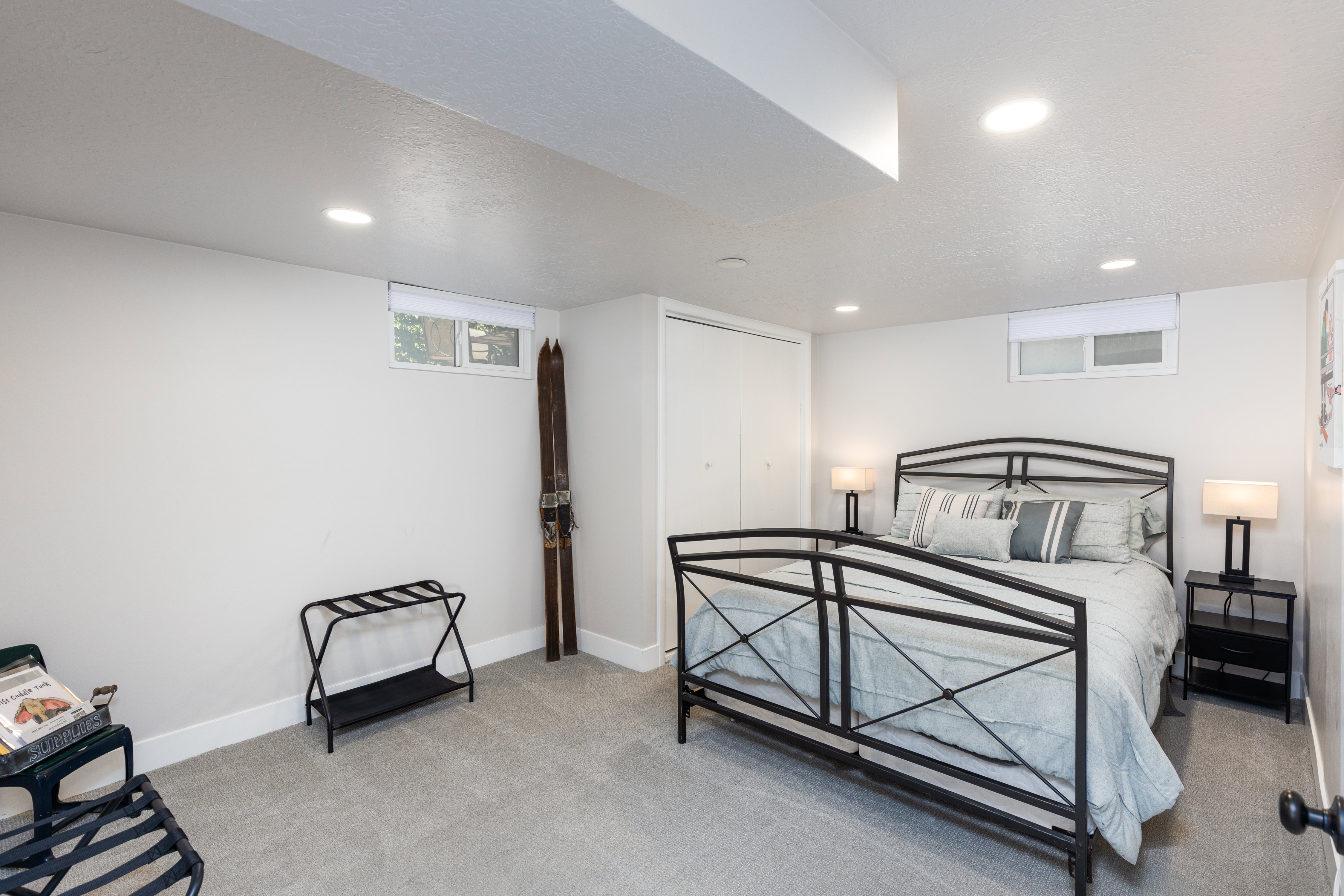 Carpeted bedroom featuring recessed lighting, a built-in closet with bi-fold doors, and a window with a roller shade