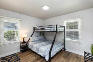 Room featuring wood-finish flooring, light grey painted walls, and white baseboards