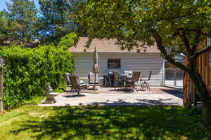 Outdoor patio featuring stamped concrete, surrounded by lush green foliage and mature trees