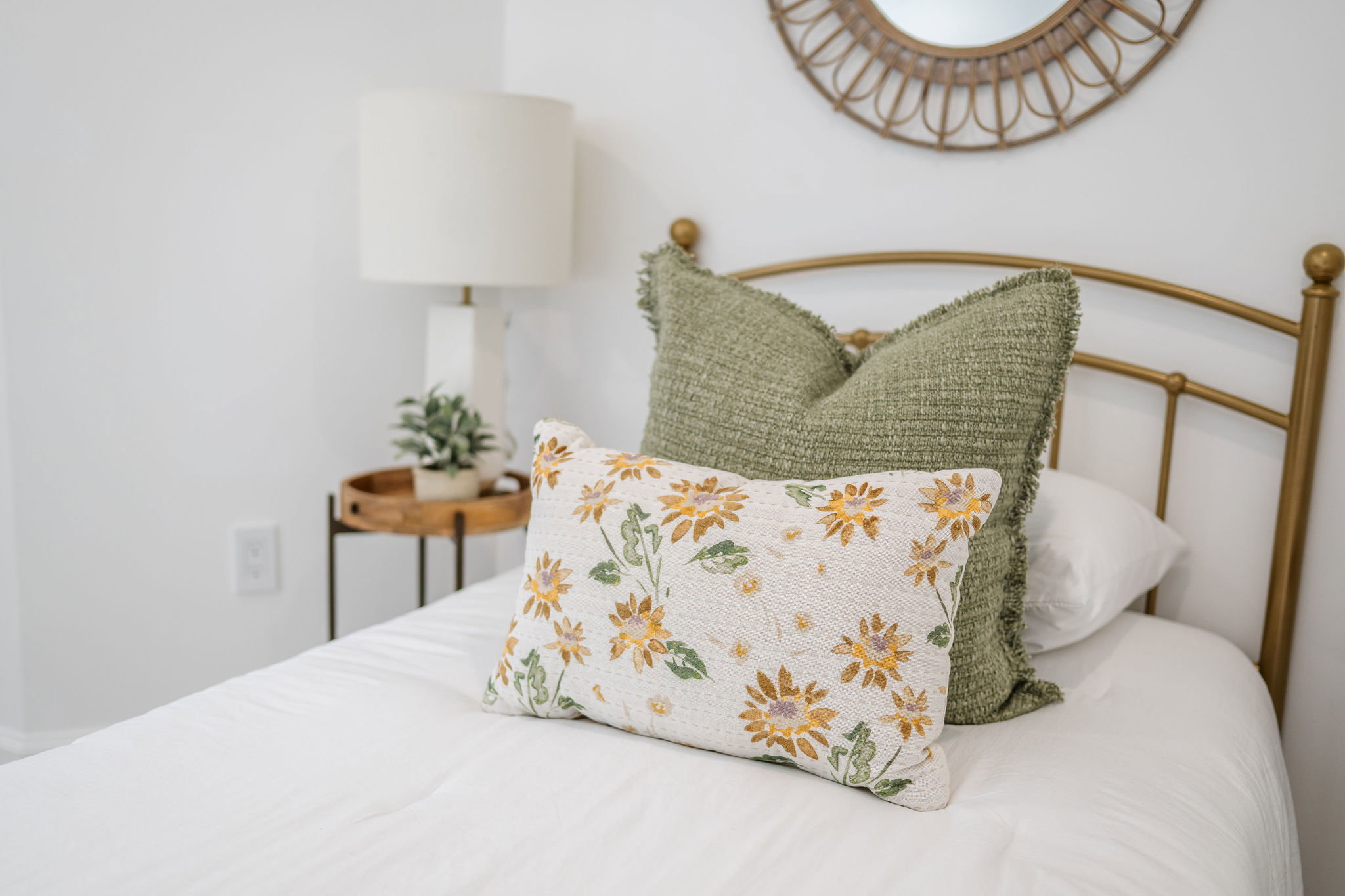 White painted wall featuring a gold-finish metal headboard