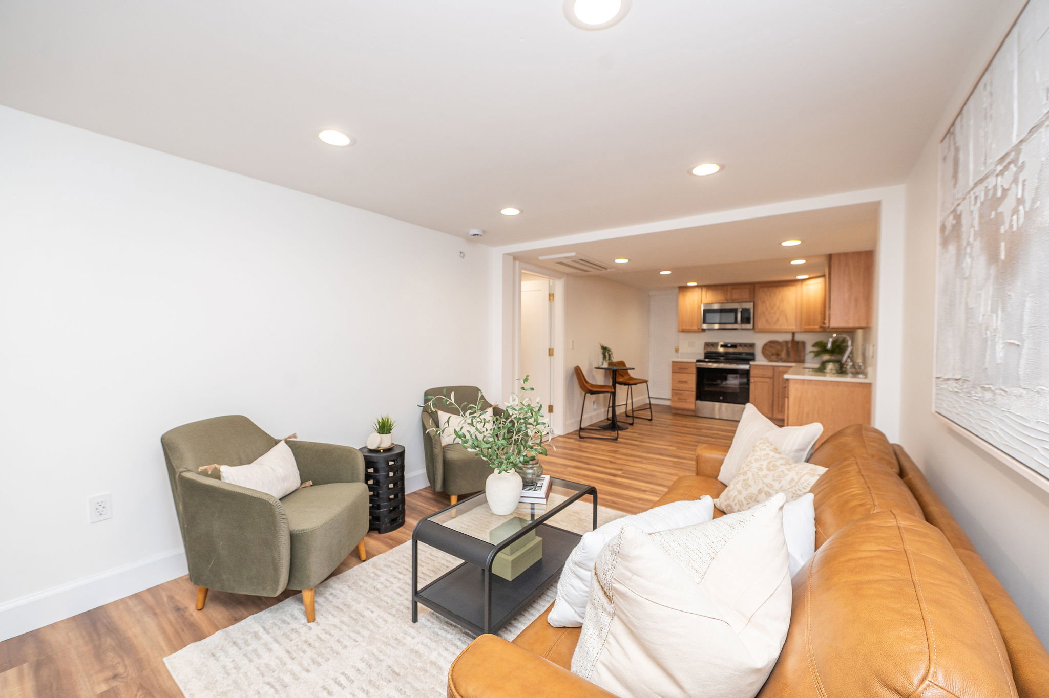 Open-concept living space featuring wood-finish flooring, recessed lighting, and a neutral color palette