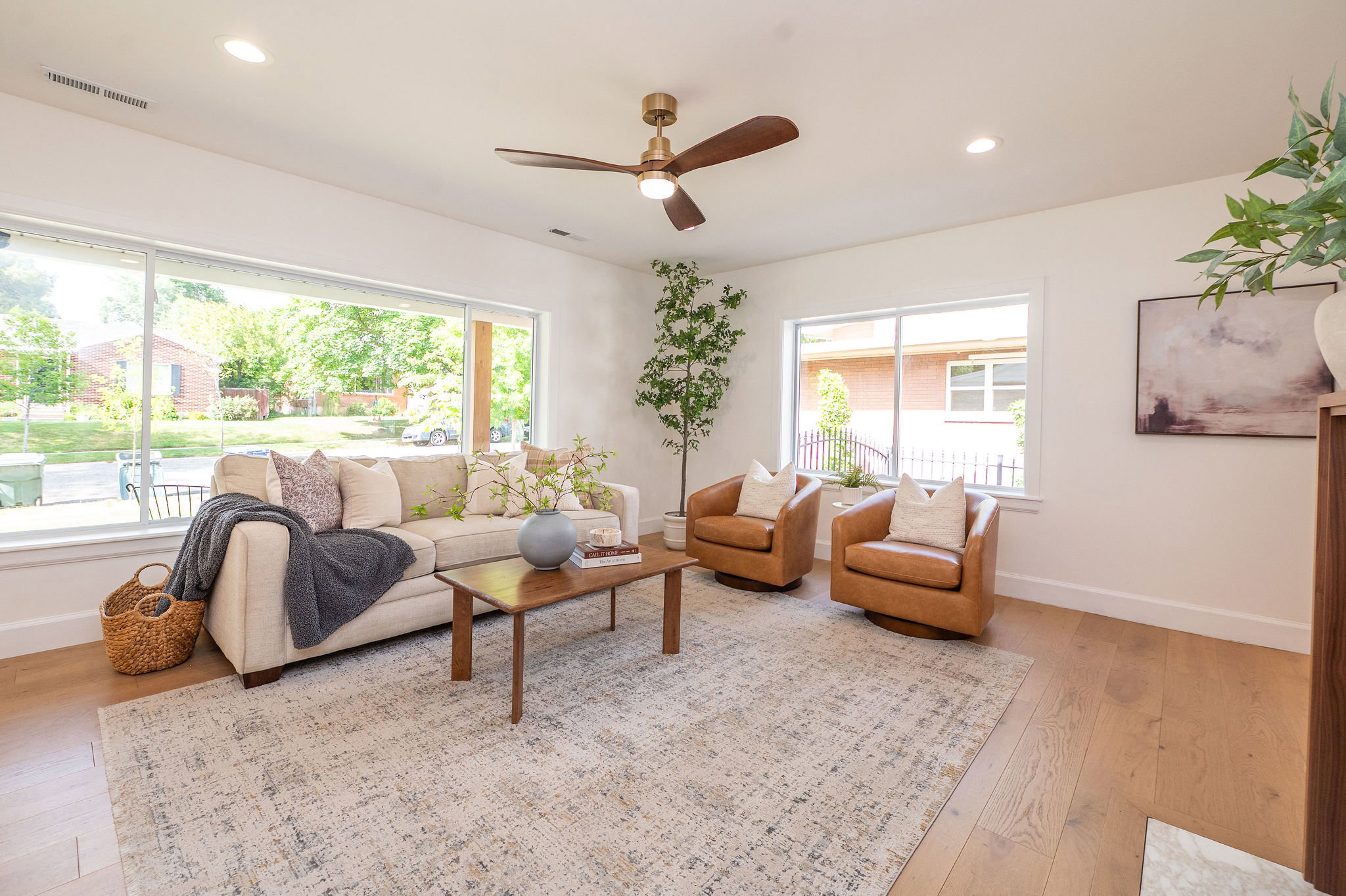 Living area featuring expansive windows, wood-finish flooring, a contemporary ceiling fan, recessed lighting, and a neutral color palette