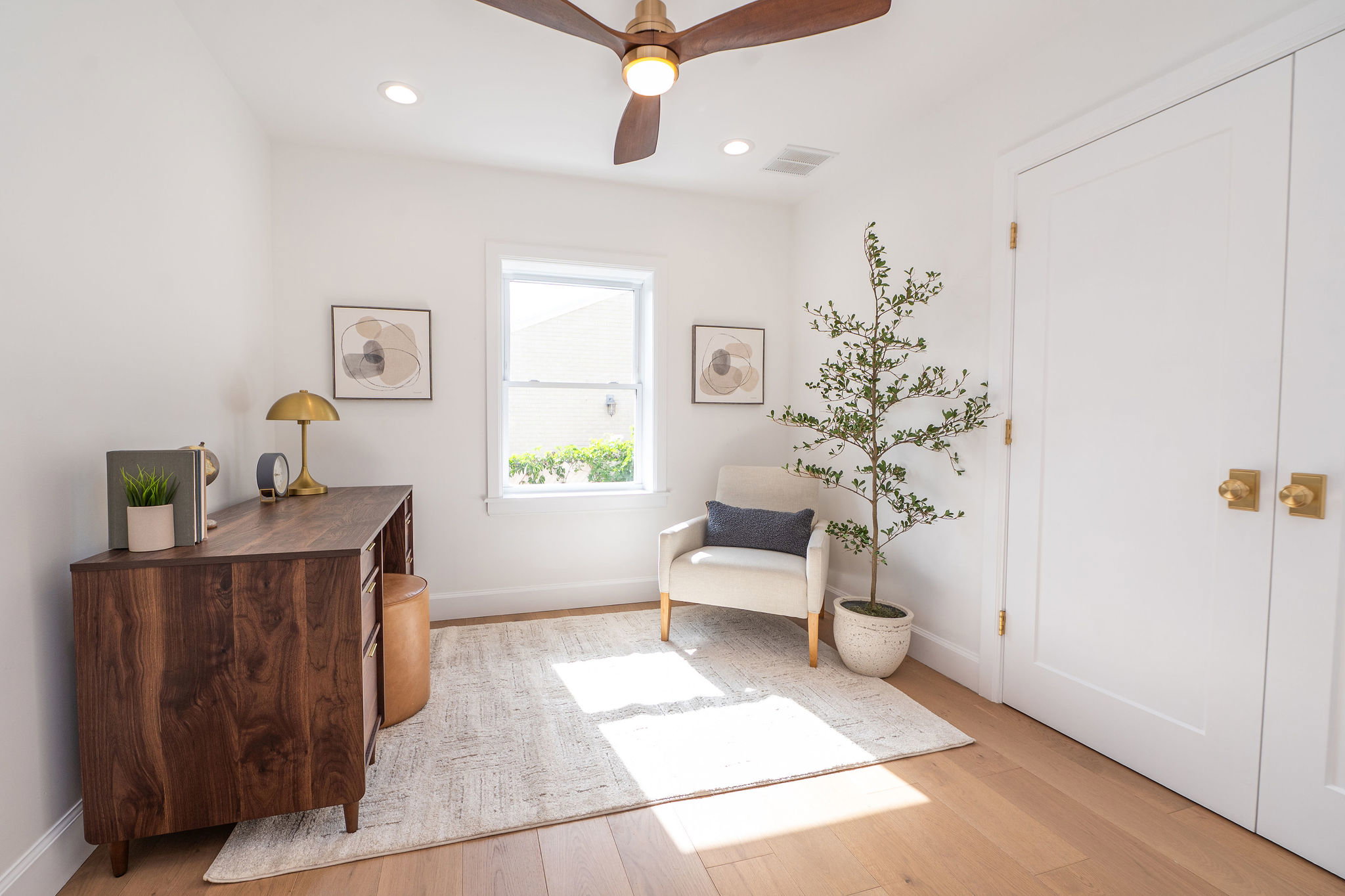 Light-filled room featuring wood-finish flooring, a ceiling fan with integrated lighting, recessed ceiling lighting, a window with natural light, and double closet doors with brass hardware