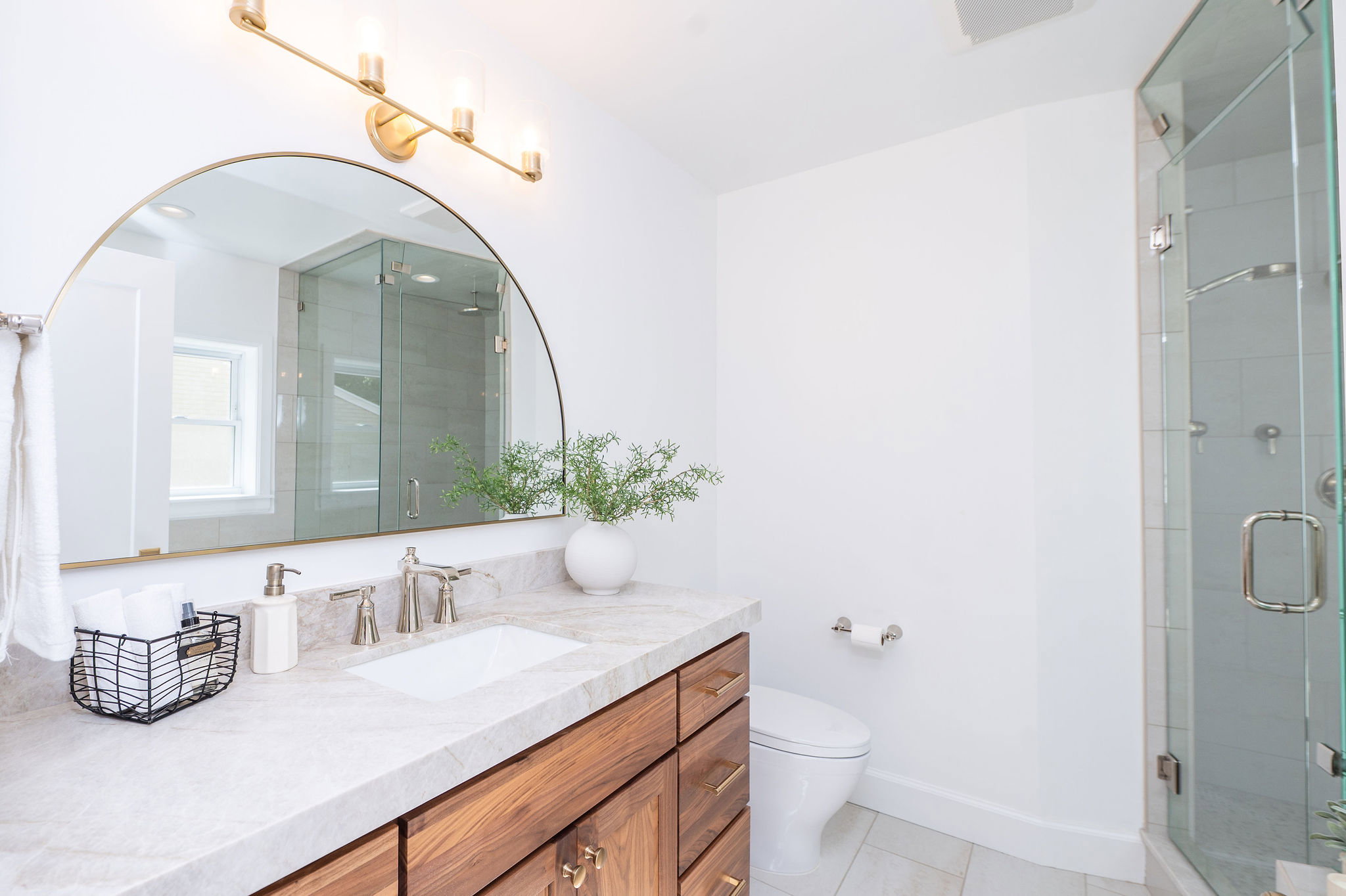 Bathroom featuring a wood-finish vanity with an undermount sink, a light-toned countertop, and brushed nickel fixtures