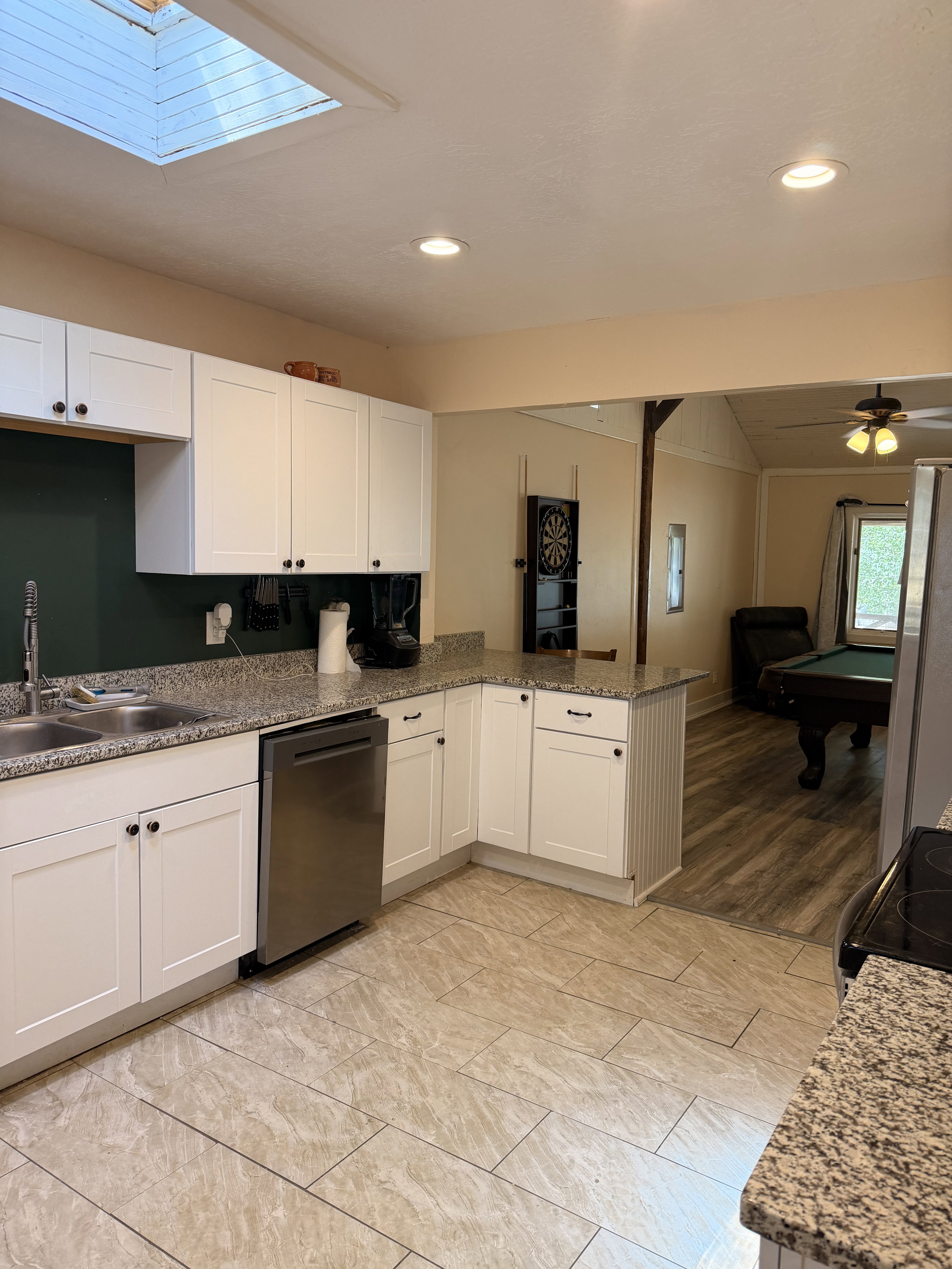 Kitchen featuring white shaker-style cabinetry, a double basin sink, and stainless steel dishwasher