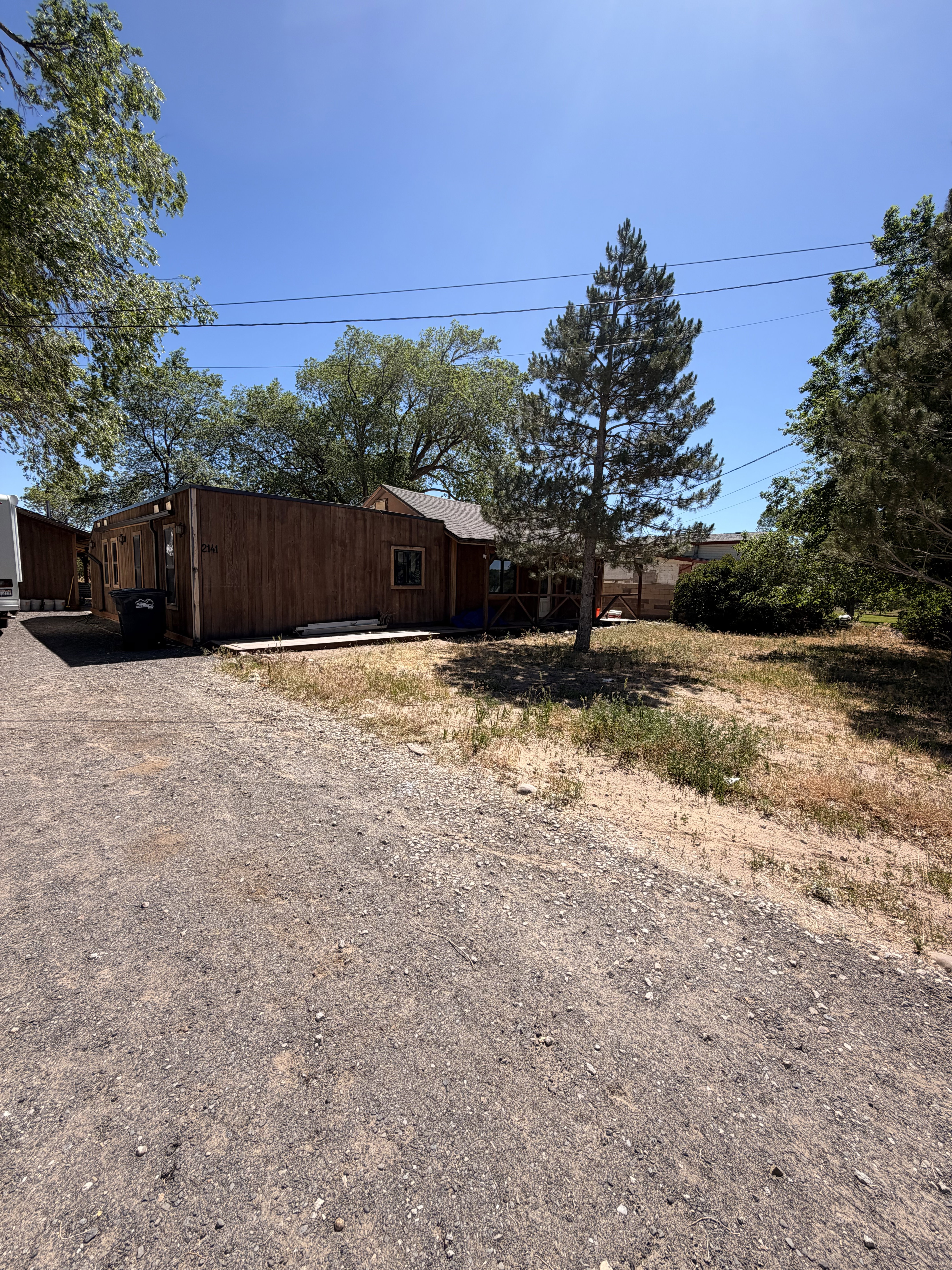 Wood-sided dwelling with a gravel driveway and natural landscaping