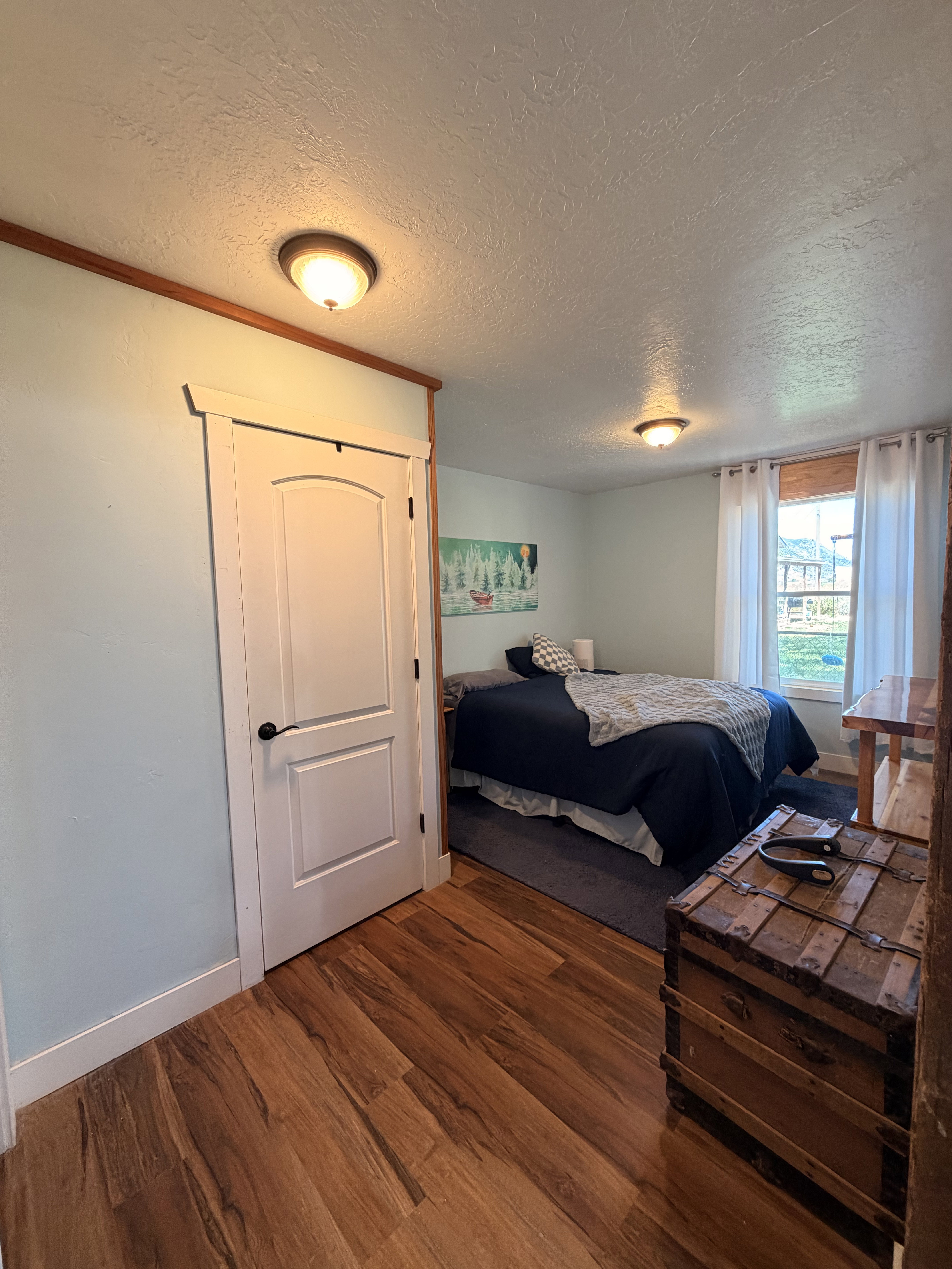 Wood-finish flooring throughout, featuring crisp white baseboards and door trim