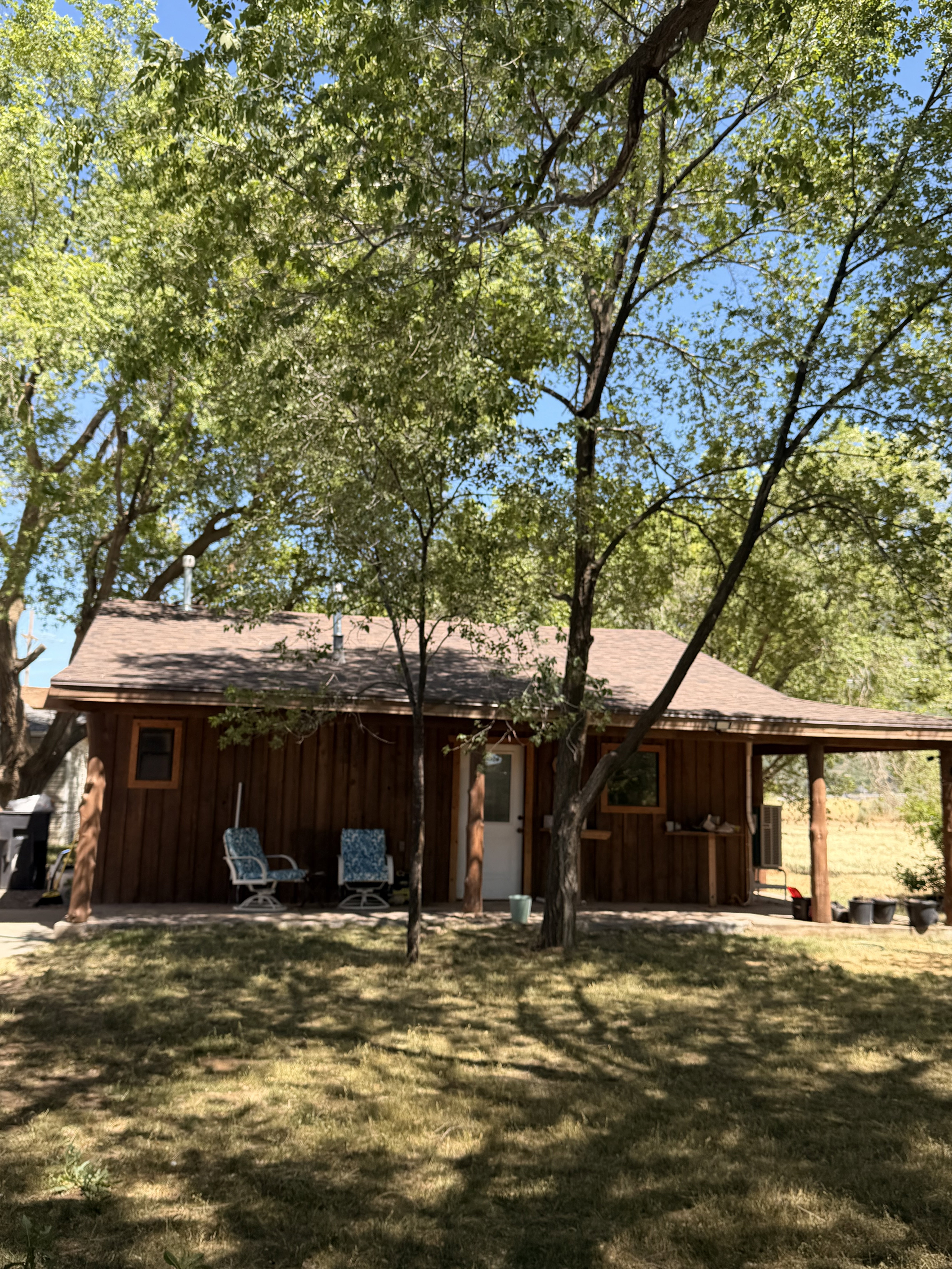 Wood-sided exterior featuring multiple mature trees