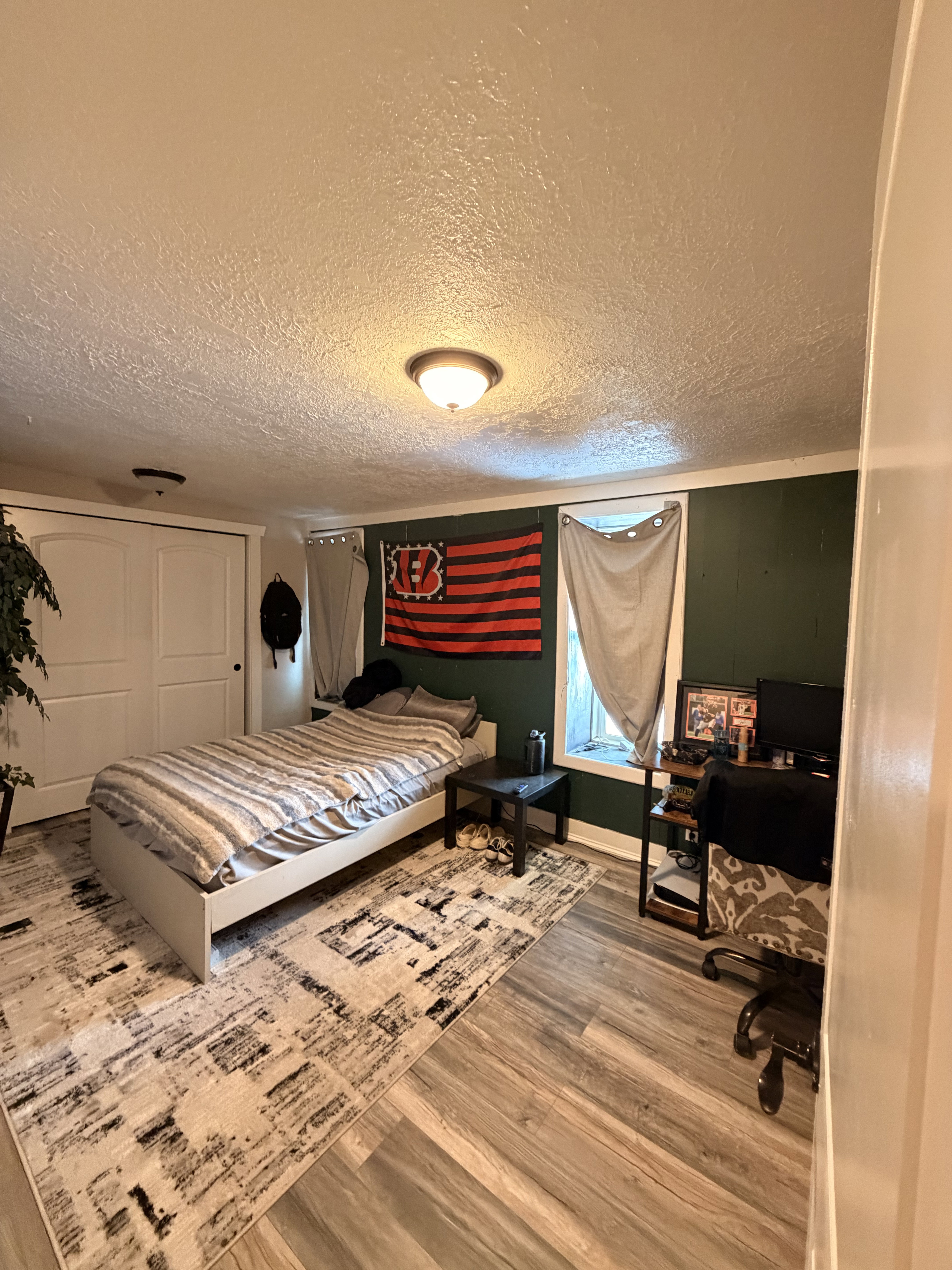 Bedroom featuring wood-finish flooring, a neutral ceiling, and a window with trim