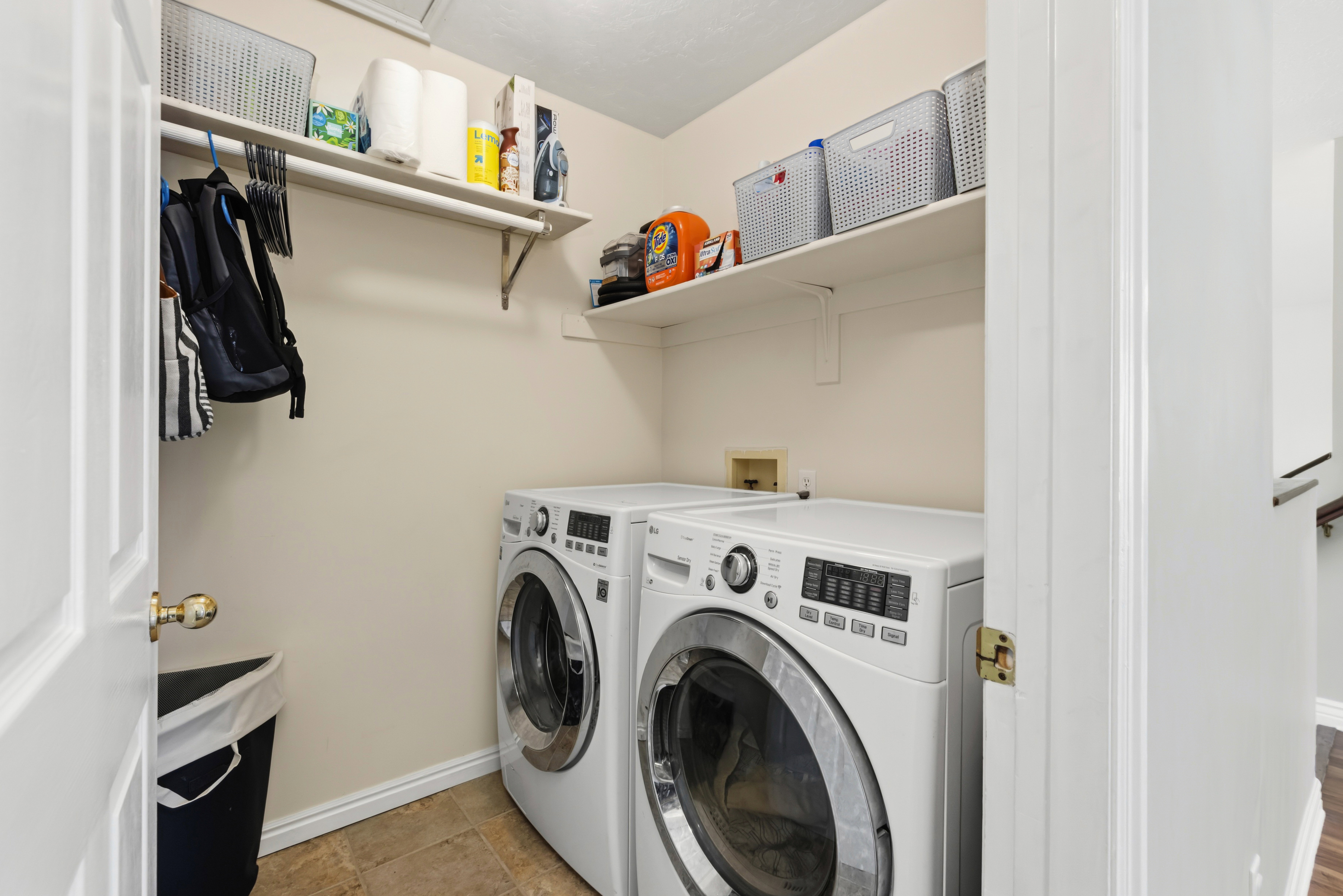 Dedicated laundry space featuring neutral-toned walls and tile flooring