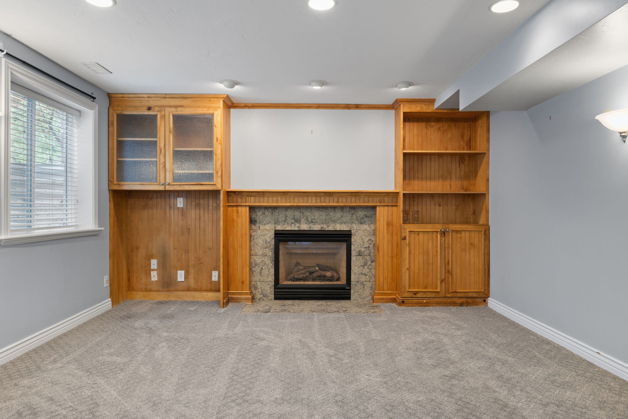 Stone-surround fireplace with built-in wooden cabinetry