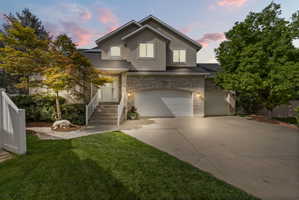 Traditional-style house with brick siding, concrete driveway, an attached garage, solar panels, and stucco siding