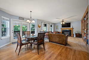 Dining room featuring a tiled fireplace and light wood-style floors