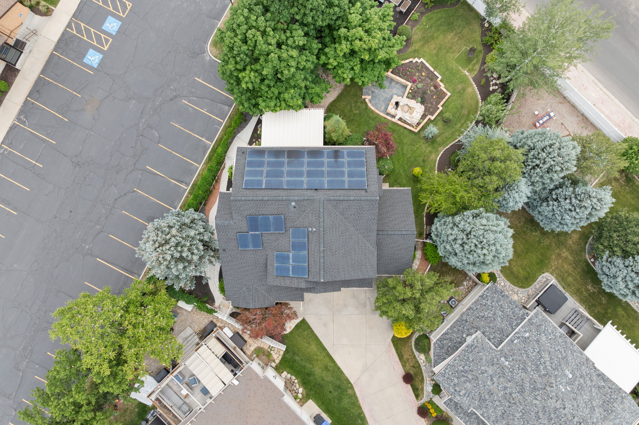 Gray shingle roof home featuring multiple solar panel arrays
