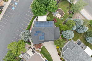 Gray shingle roof home featuring multiple solar panel arrays