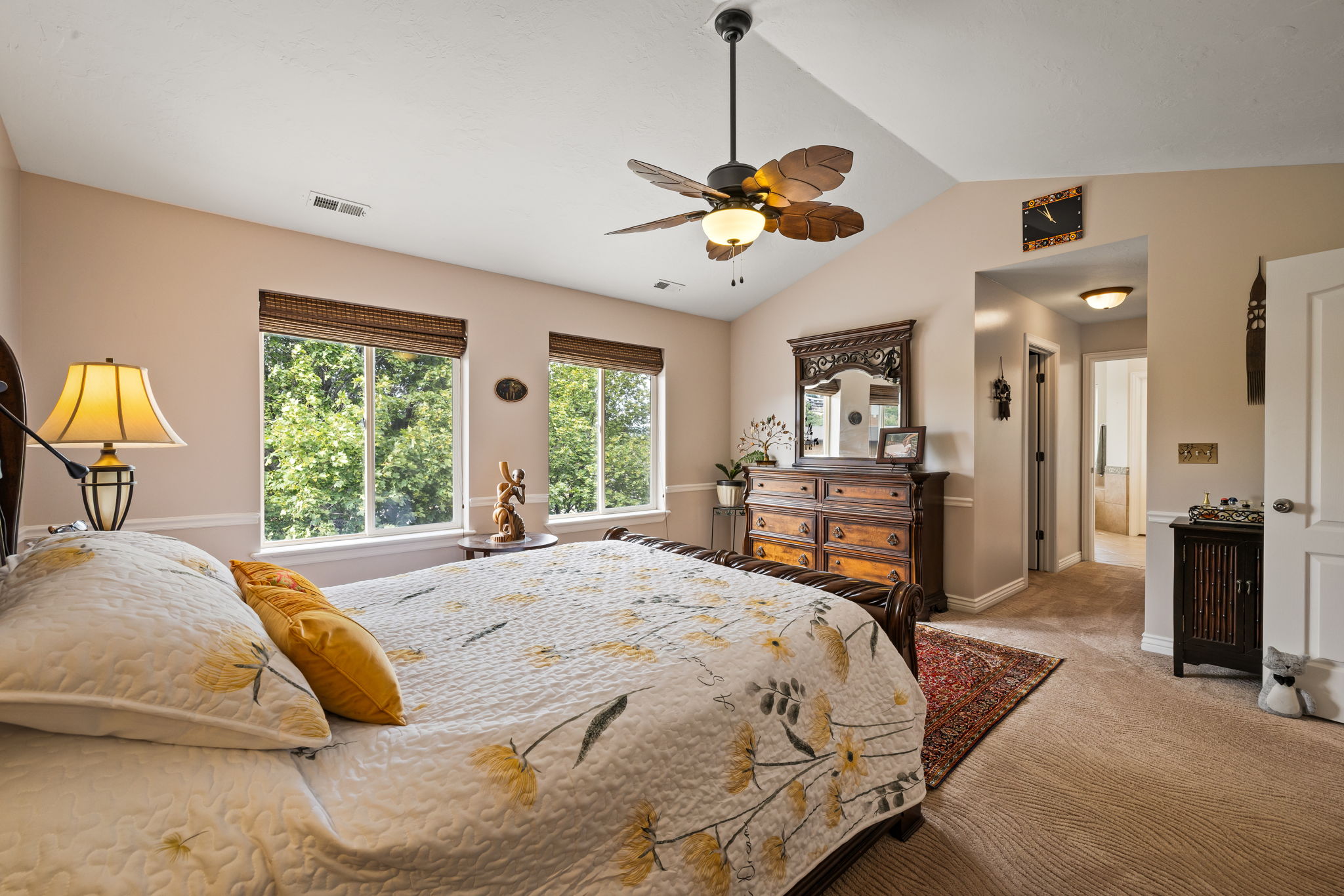 Carpeted bedroom with lofted ceiling and ceiling fan