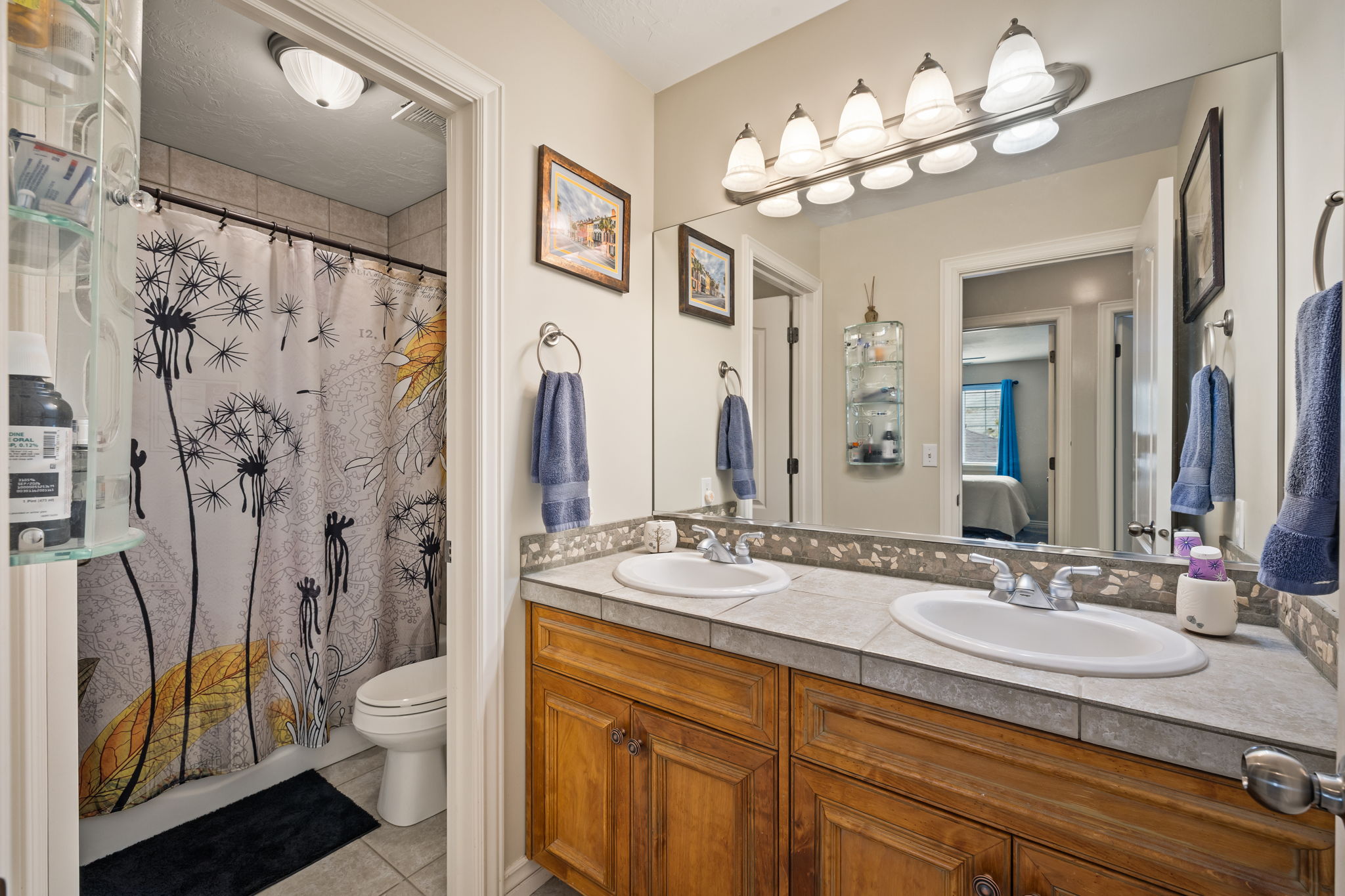 Bathroom with ensuite bathroom, light tile patterned flooring, double vanity, and shower / bath combo