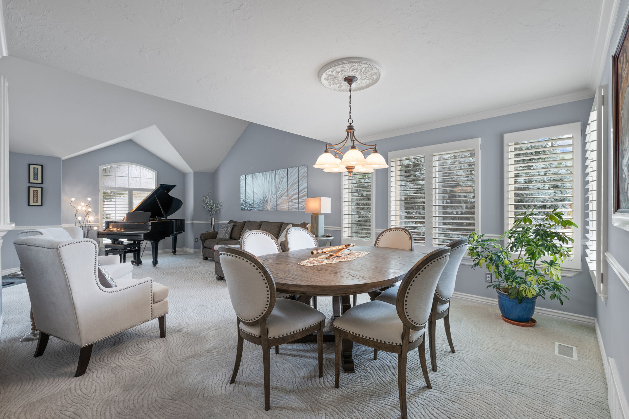 Open-concept common area featuring vaulted ceilings and a chandelier over a dining space