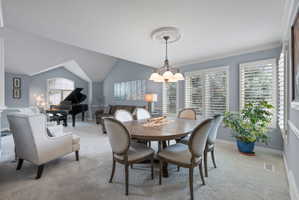 Open-concept common area featuring vaulted ceilings and a chandelier over a dining space