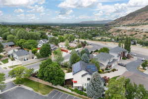 Aerial perspective showcasing a residential area with diverse home styles, mature trees, and a distant mountain range