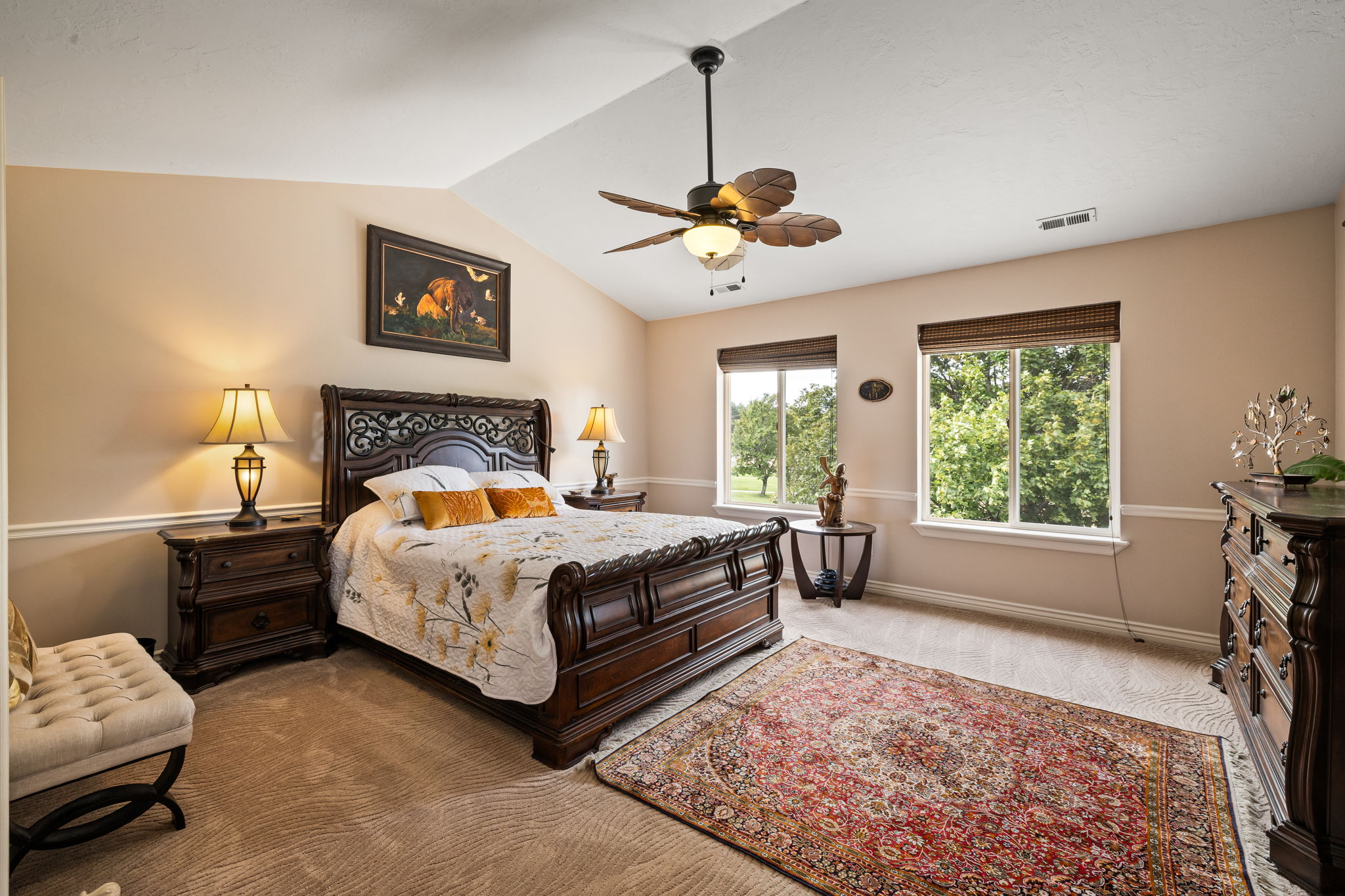 Bedroom featuring lofted ceiling, a ceiling fan, and light carpet