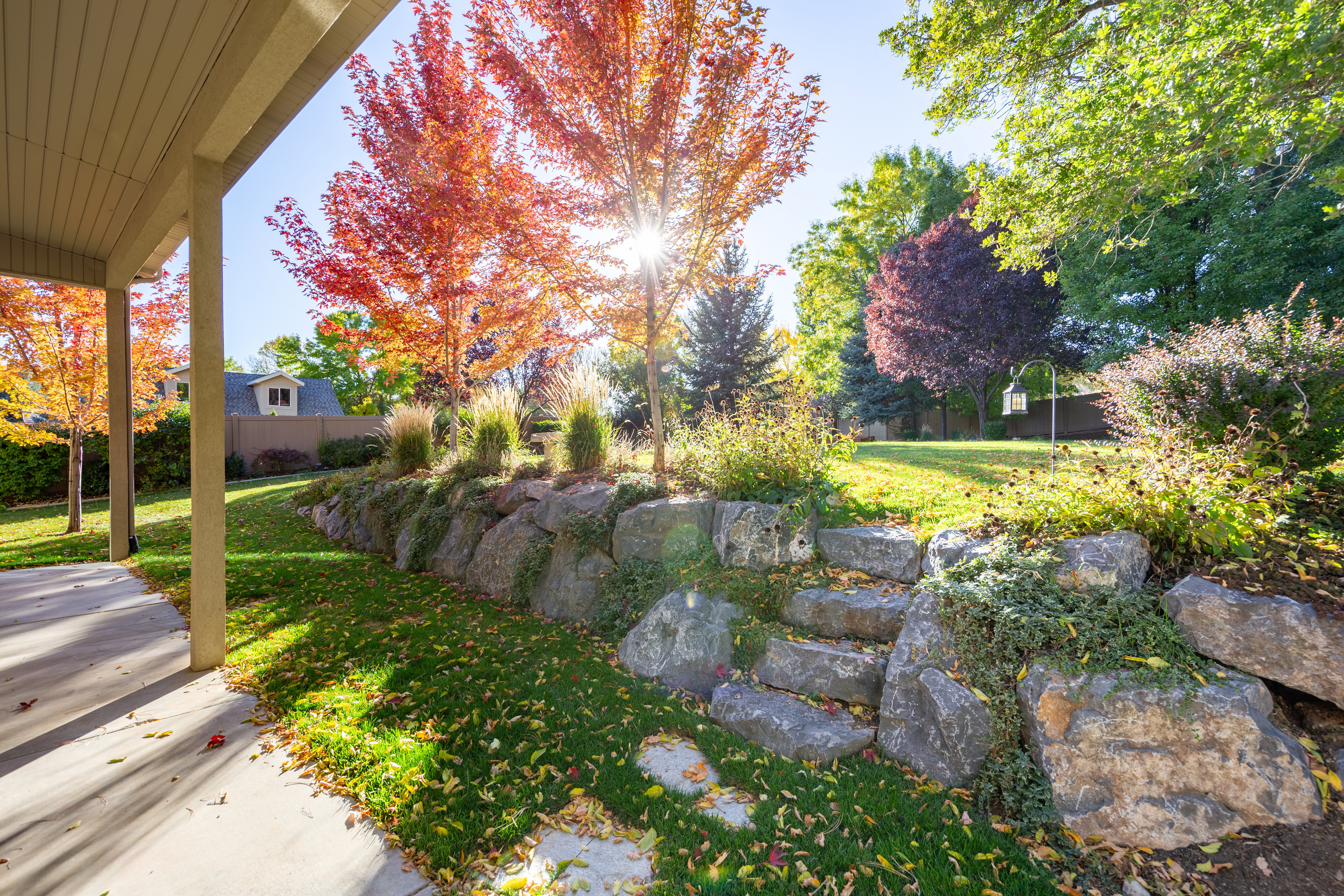 Stone retaining wall with integrated steps leading to an expansive lawn