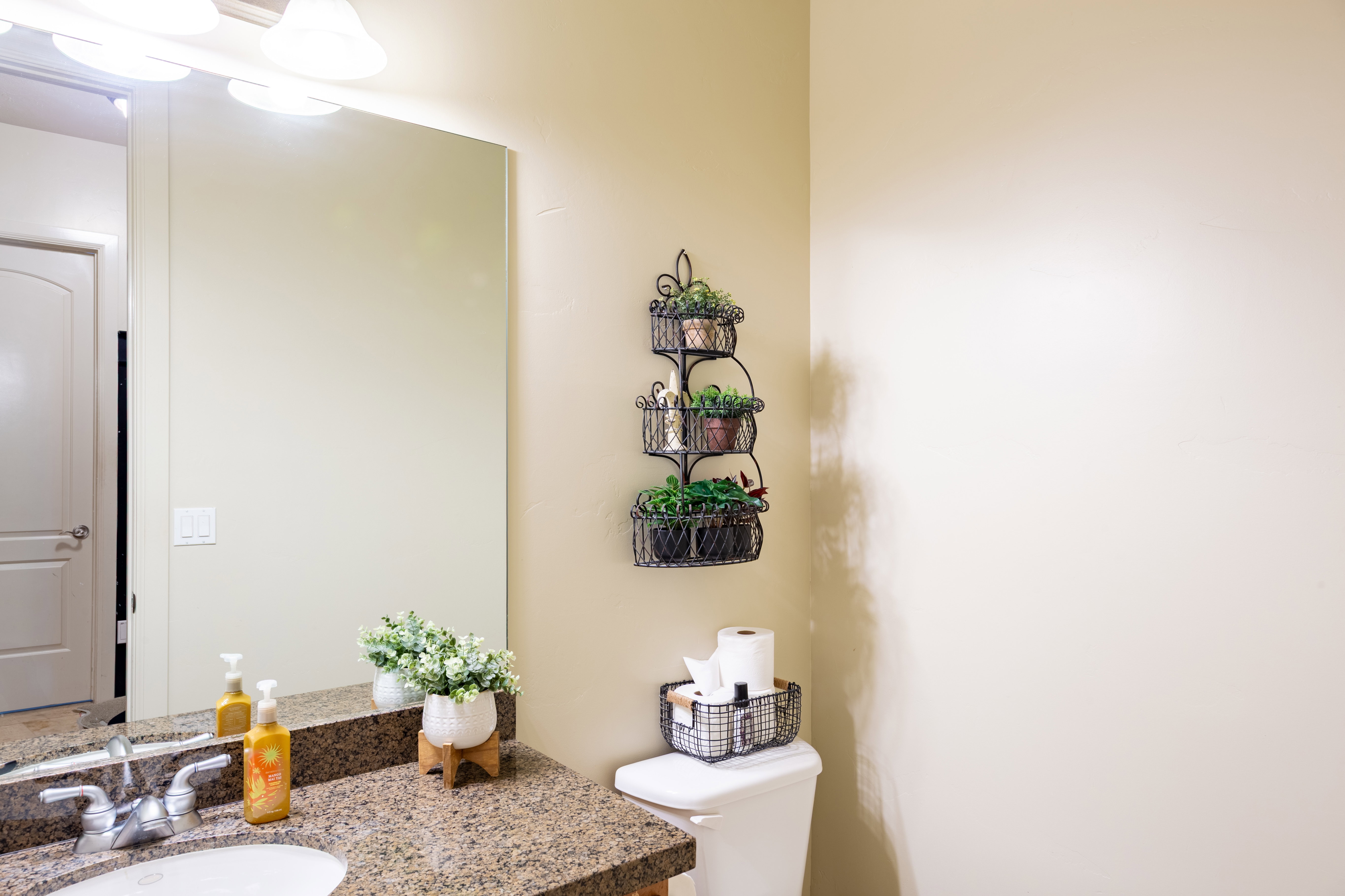 Bathroom vanity featuring a polished granite countertop with an undermount sink and chrome faucet