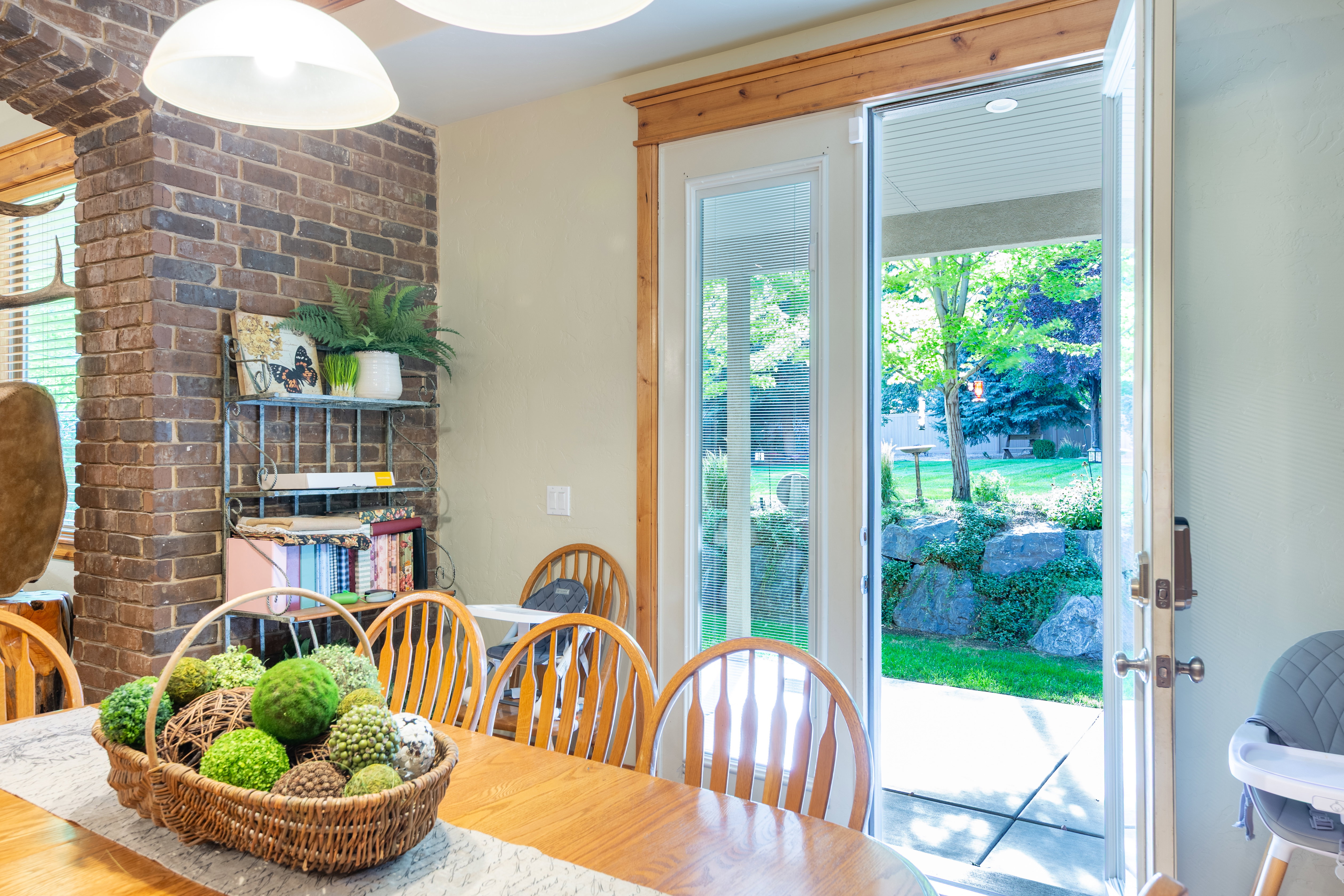 Dining area featuring a brick column, wood-finish flooring, and a glass-paneled patio door leading to an outdoor space