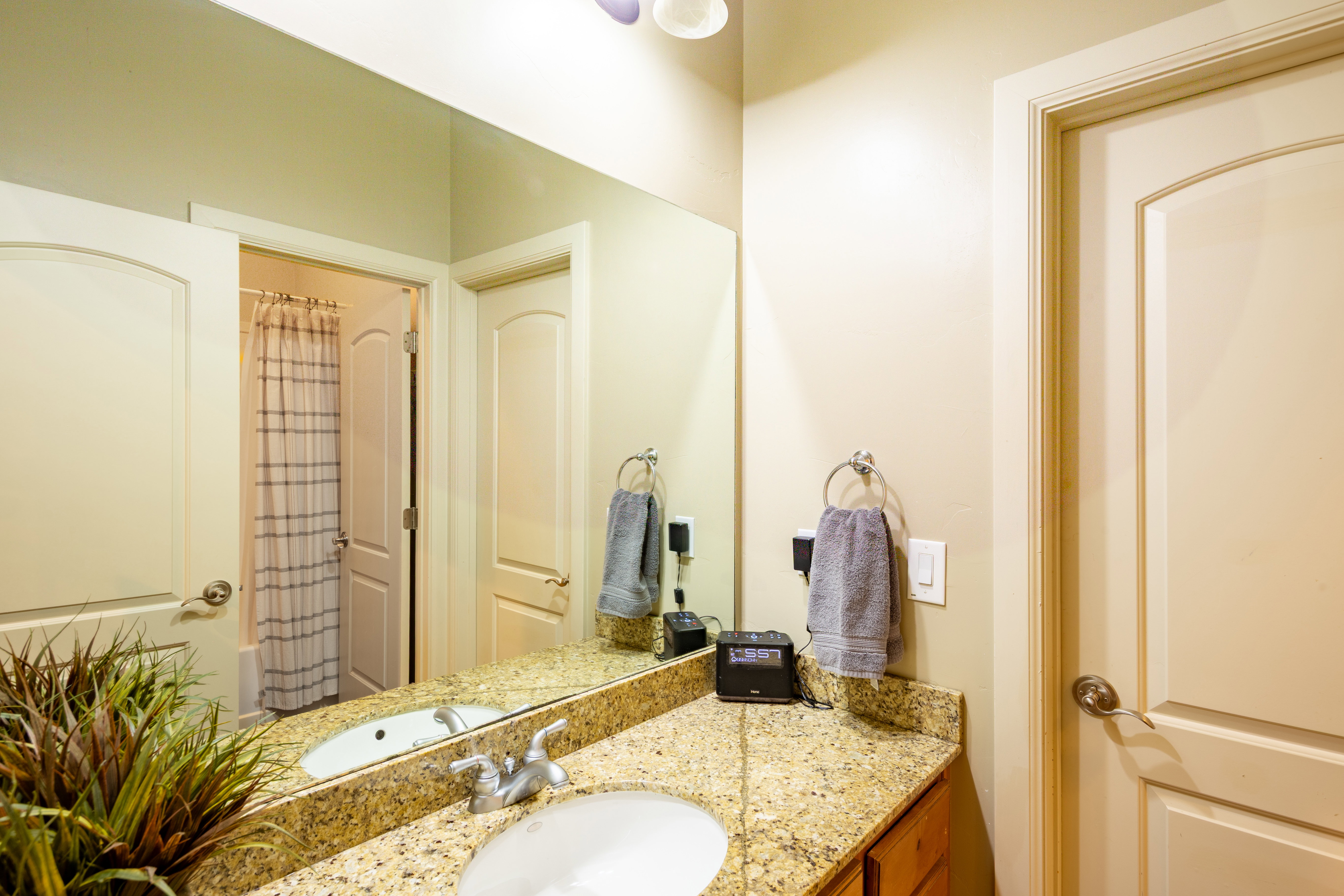 Bathroom vanity with a granite-style countertop, undermount sink, and polished chrome faucet